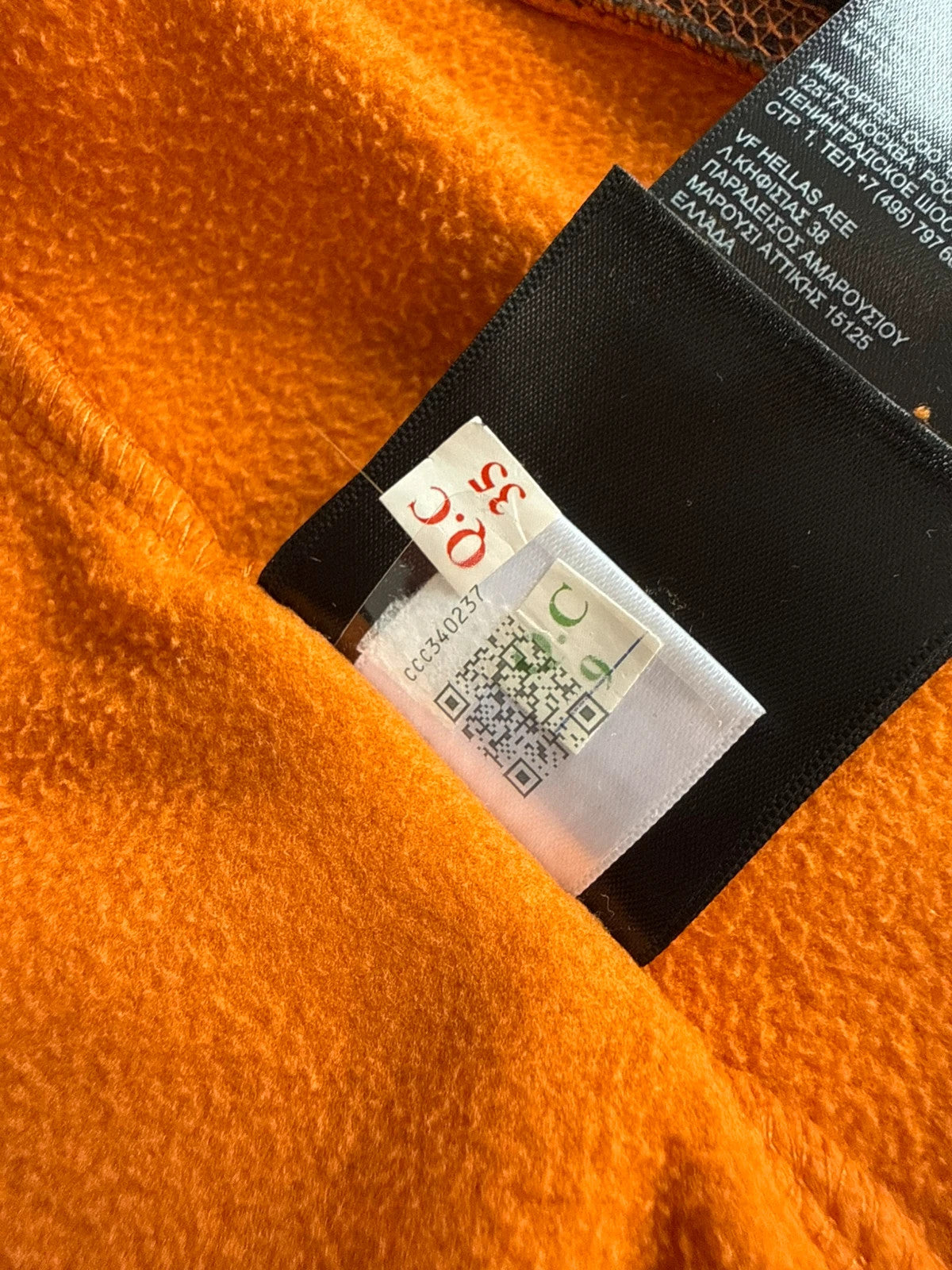 The North Face orange fleece jacket with embroidered logo and high stand collar.