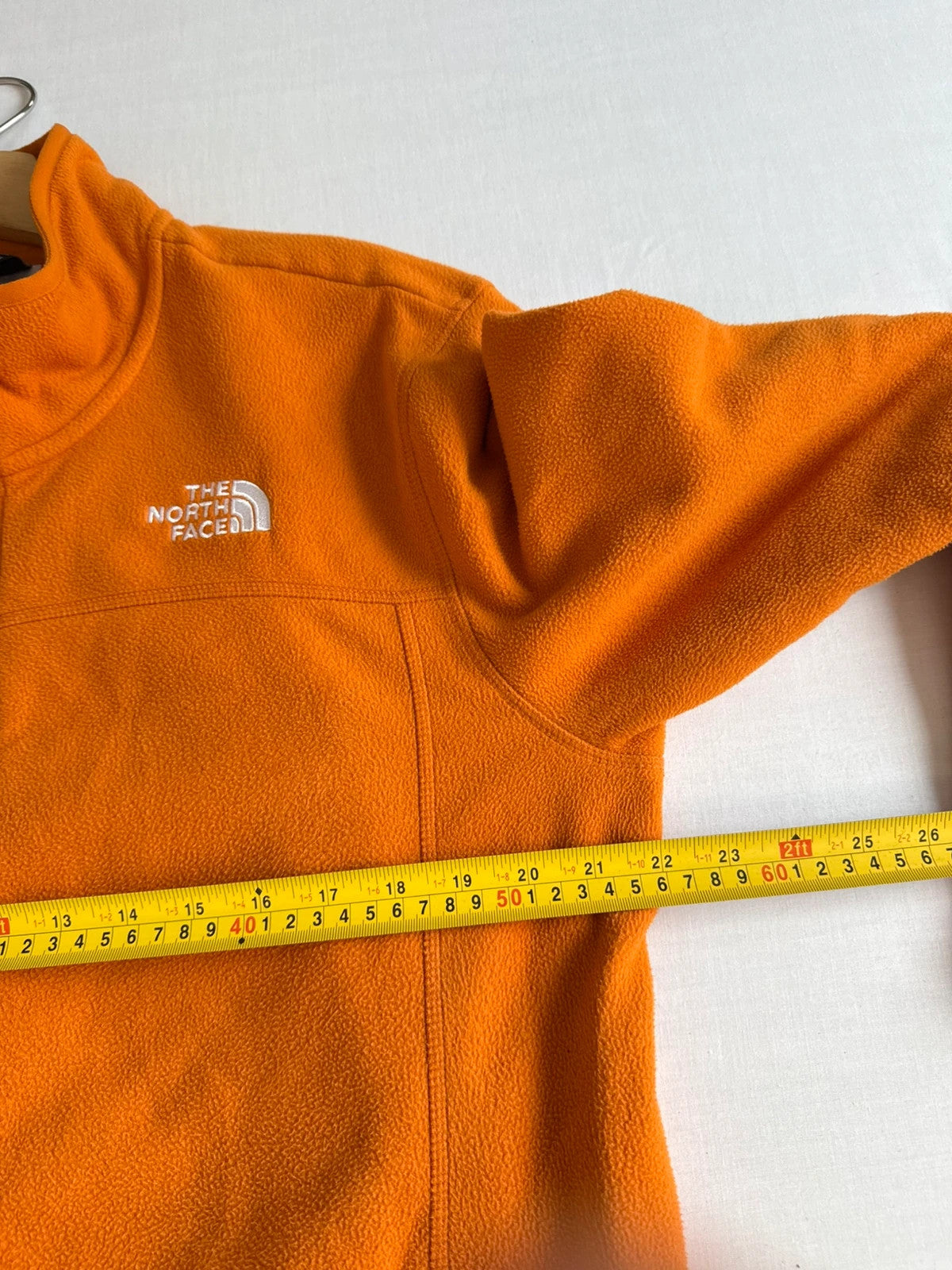 The North Face orange fleece jacket with embroidered logo and high stand collar.