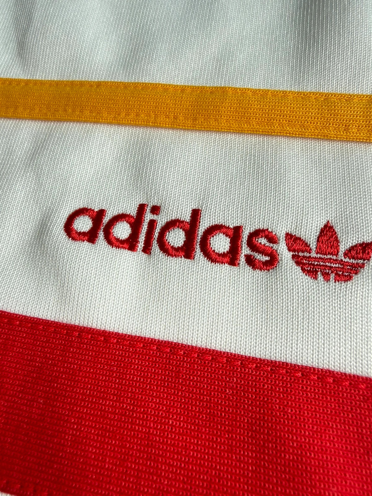 Adidas white track top with red 3-stripes, tonal stripes, full zip, stand-up collar.