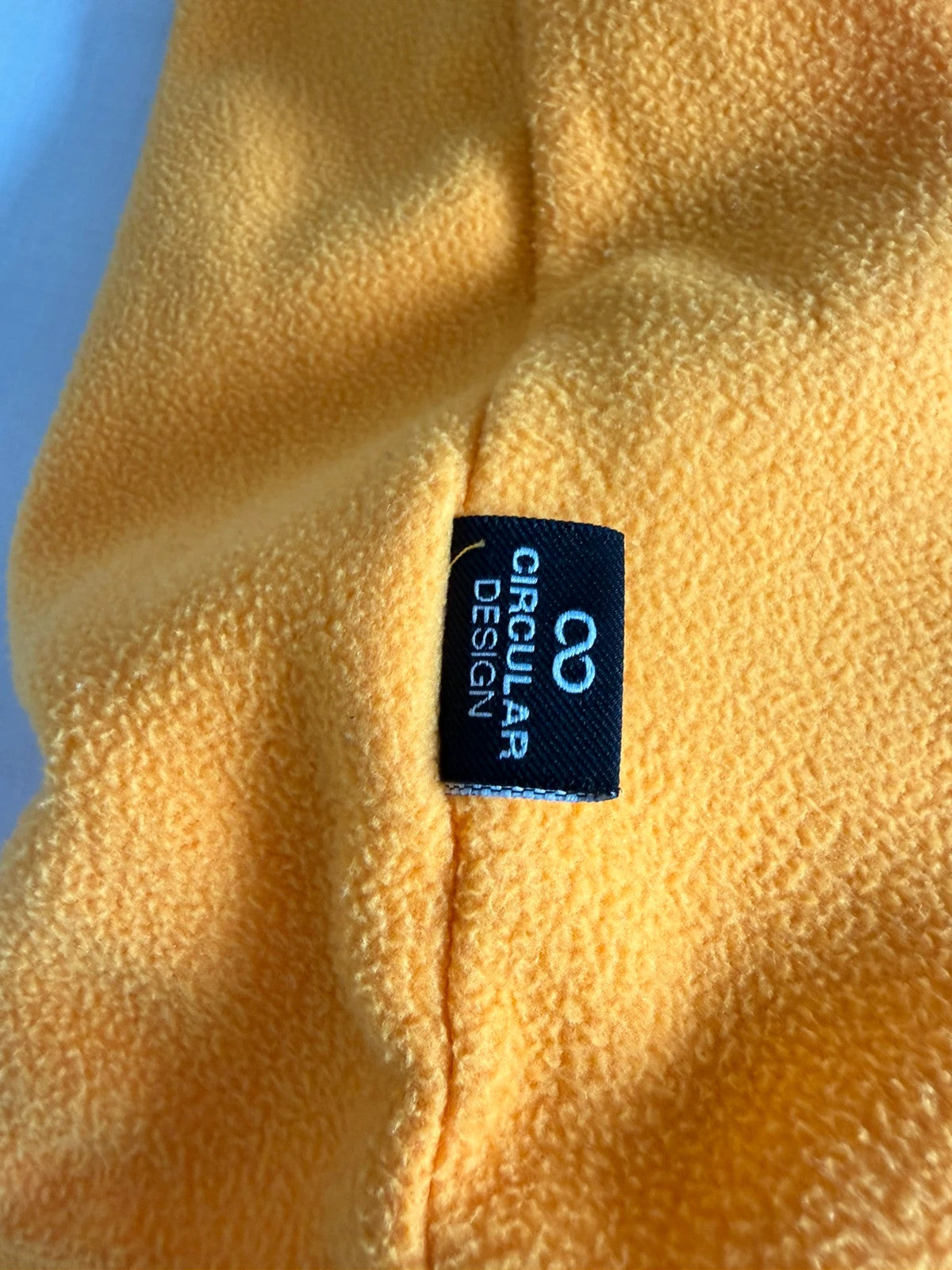 The North Face yellow fleece jacket with embroidered logo and zippered pockets.