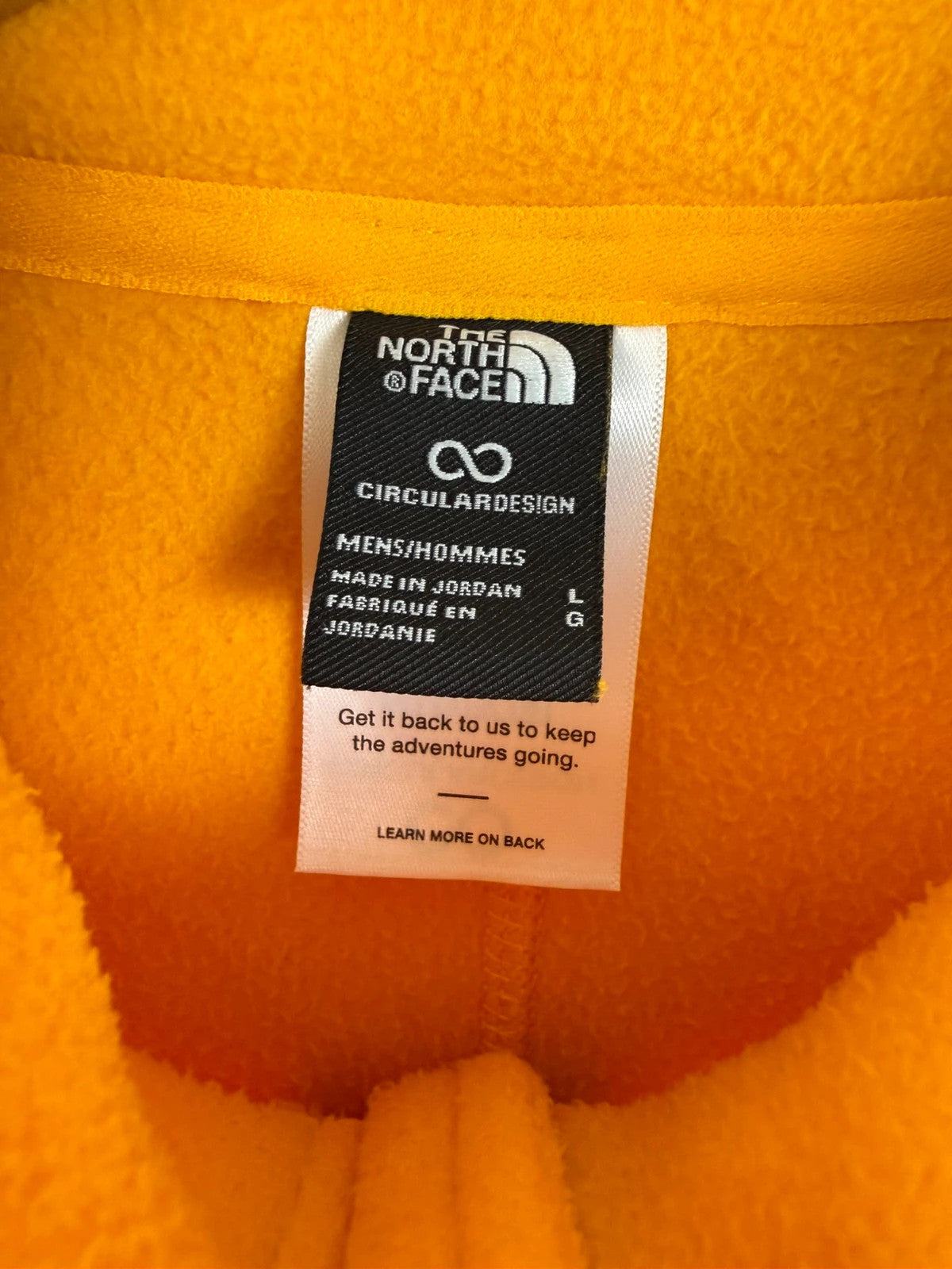 The North Face yellow fleece jacket with embroidered logo and zippered pockets.