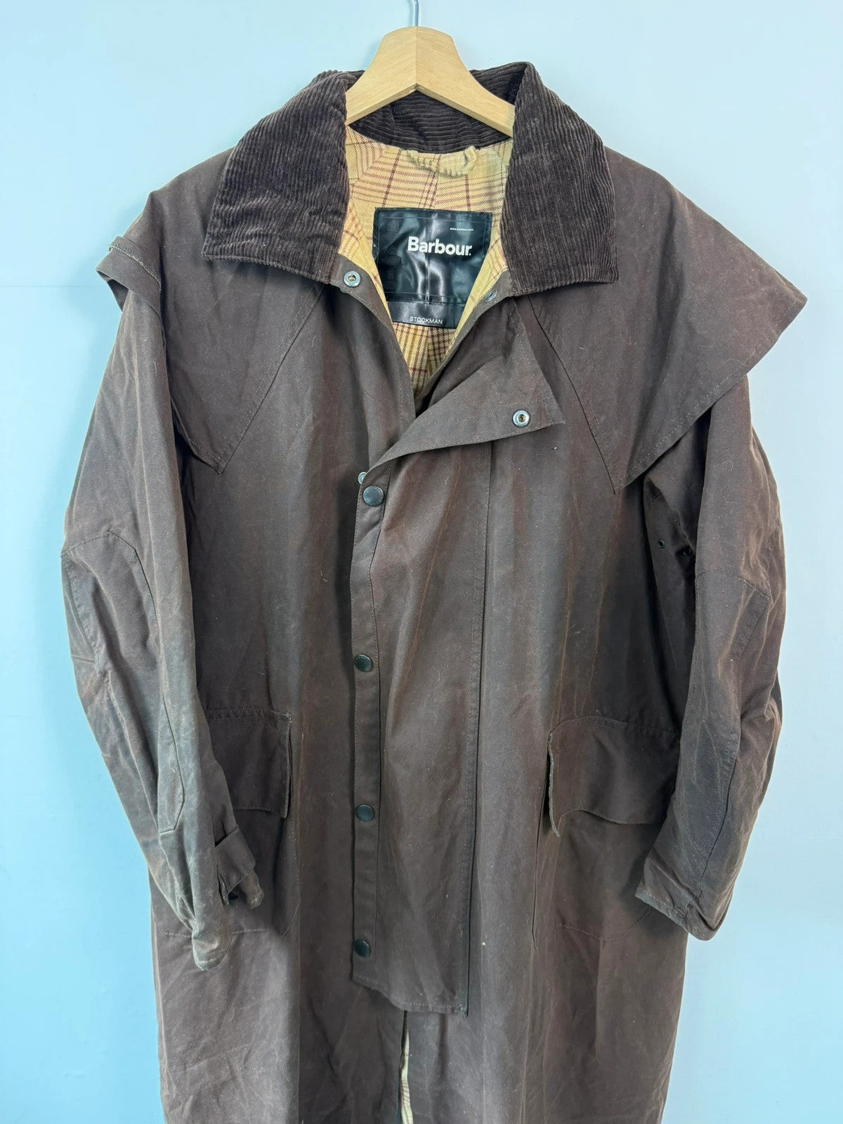 Barbour brown waxed cotton riding coat with corduroy collar and tartan lining.