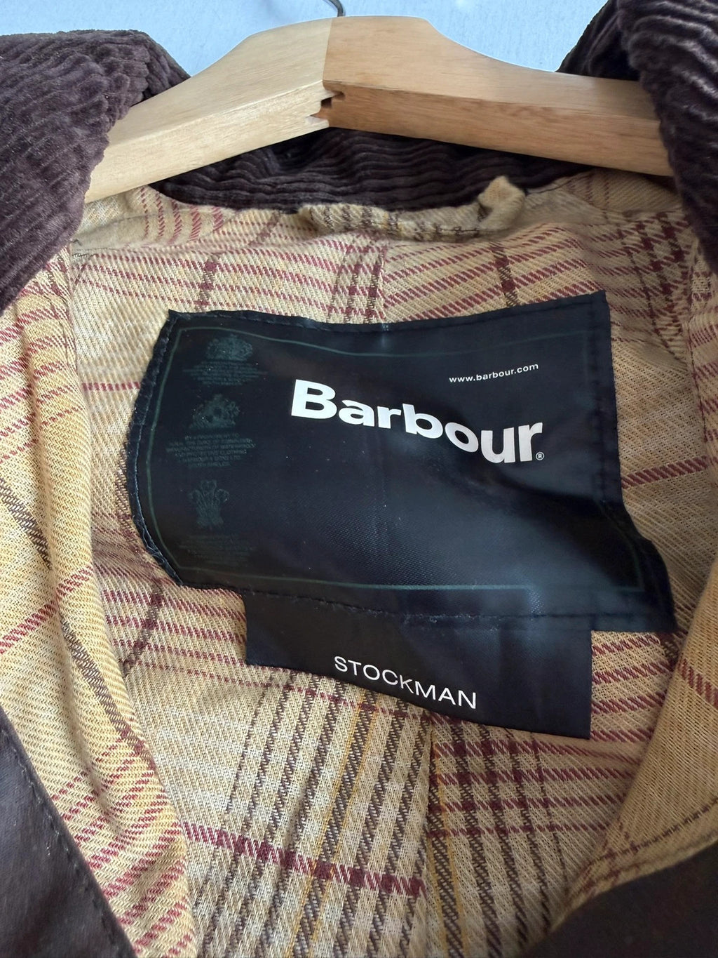 Barbour brown waxed cotton riding coat with corduroy collar and tartan lining.