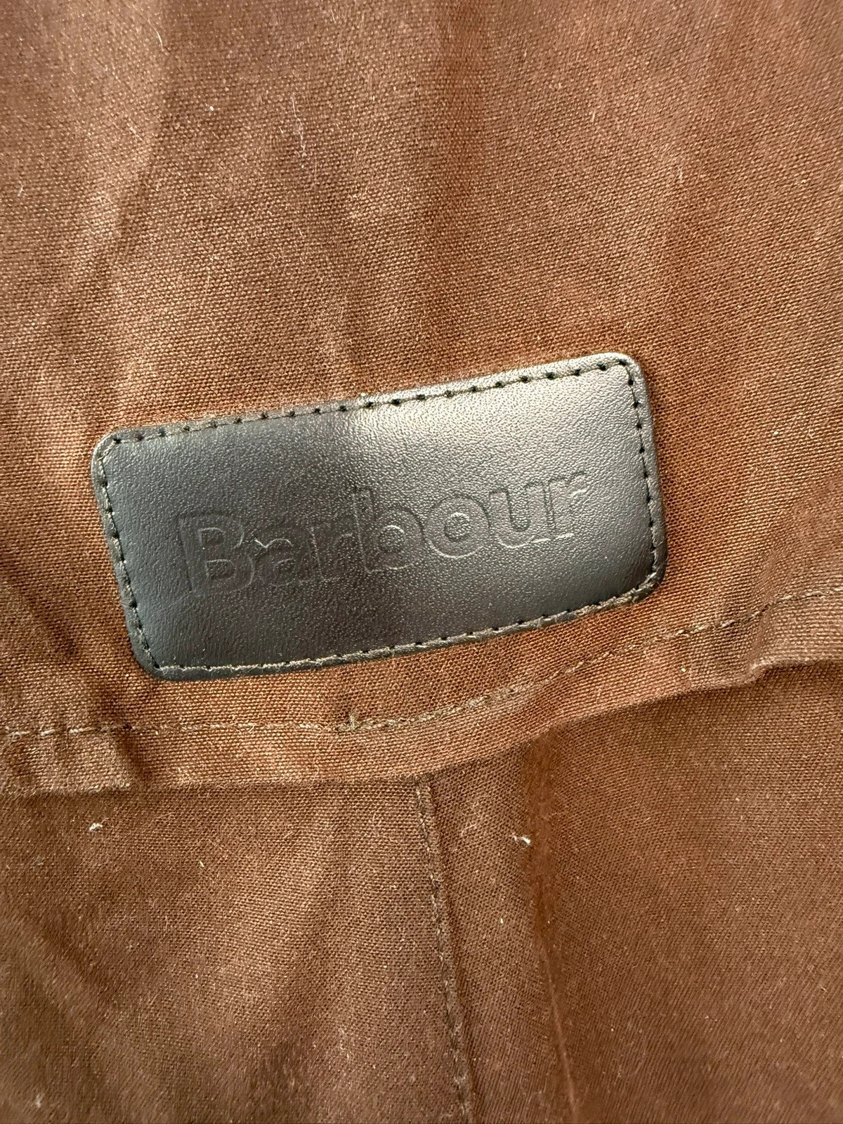 Barbour brown waxed cotton riding coat with corduroy collar and tartan lining.
