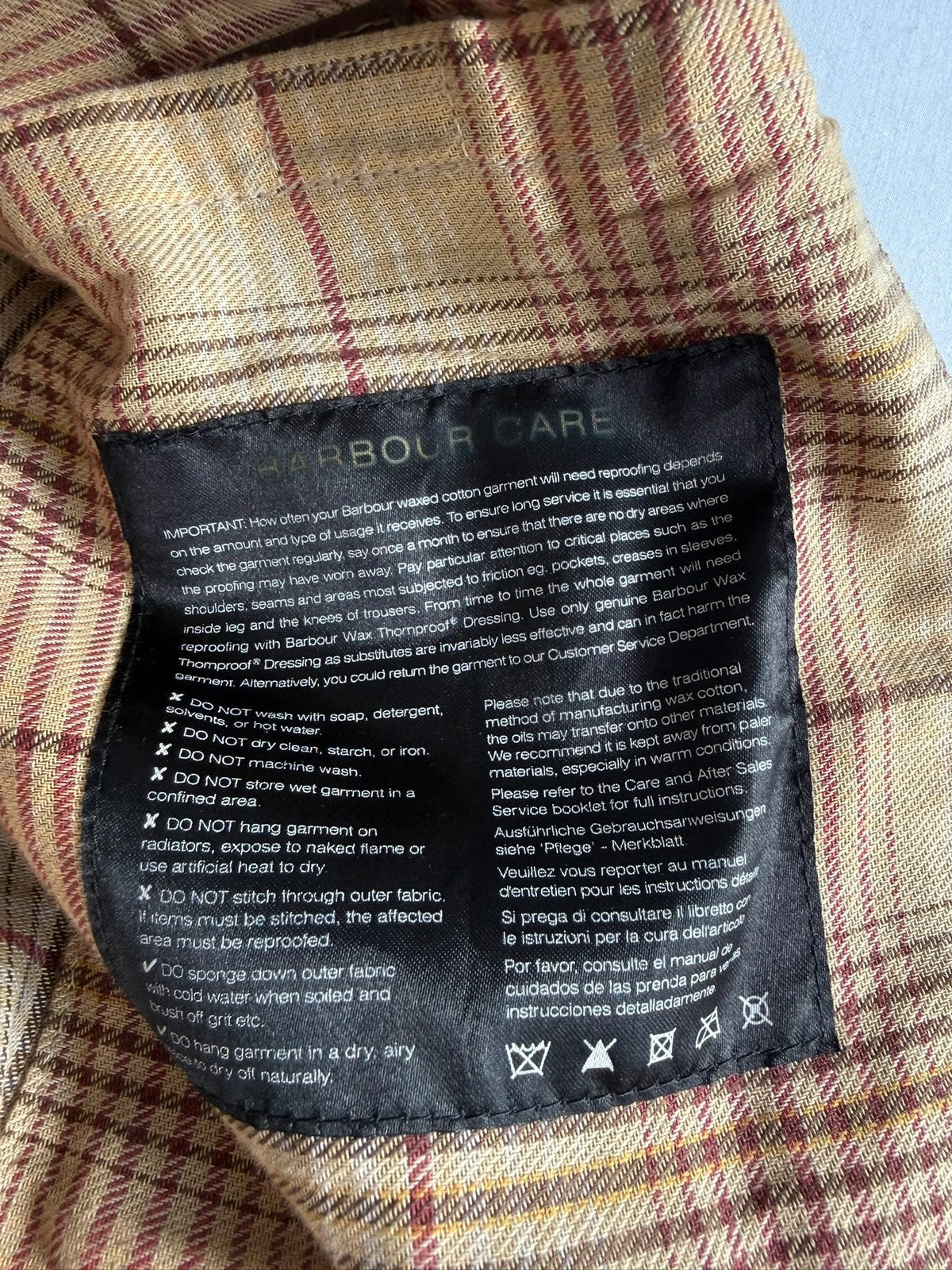 Barbour brown waxed cotton riding coat with corduroy collar and tartan lining.