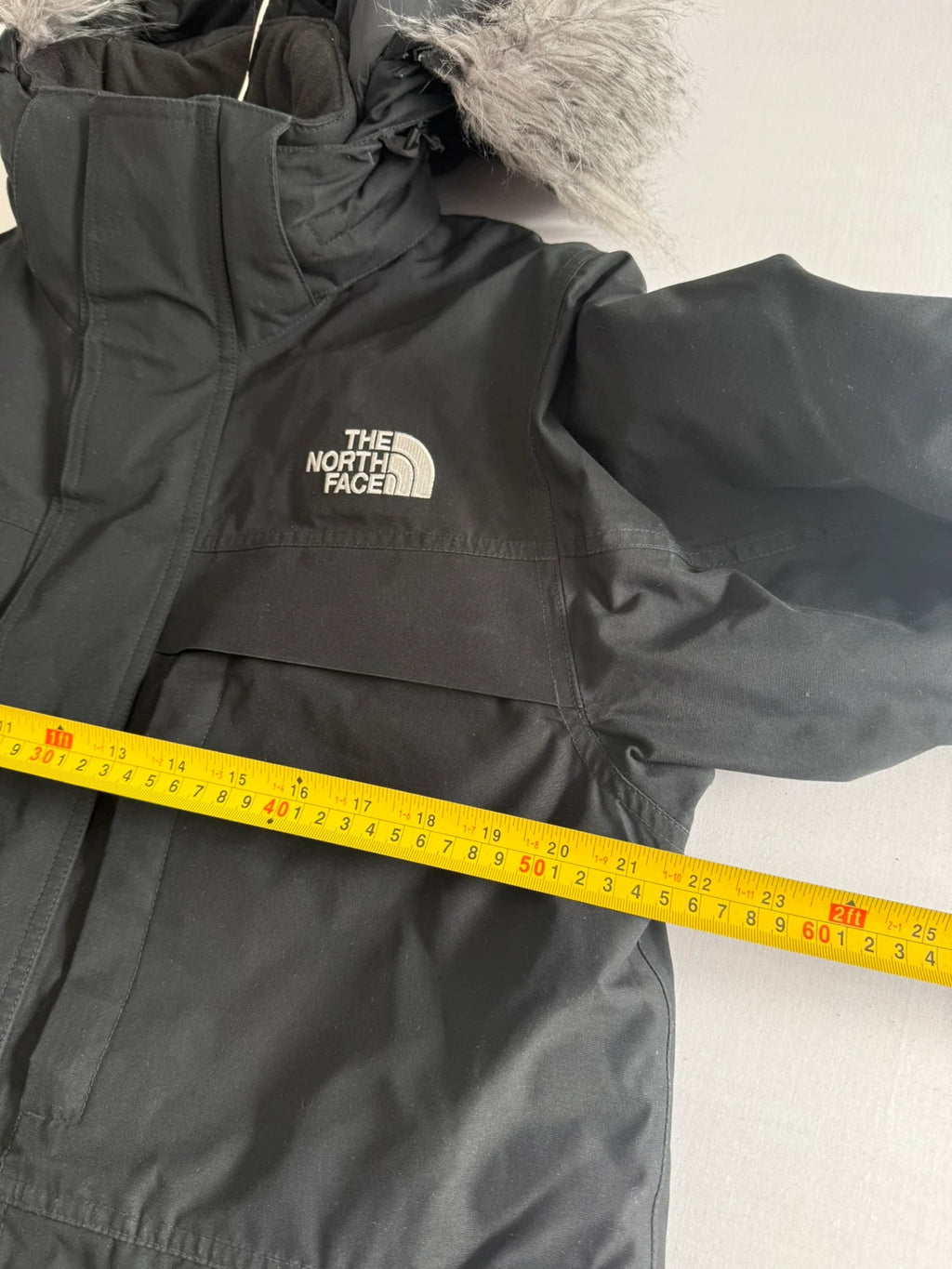 The North Face black parka with detachable faux fur hood and waterproof HyVent technology.