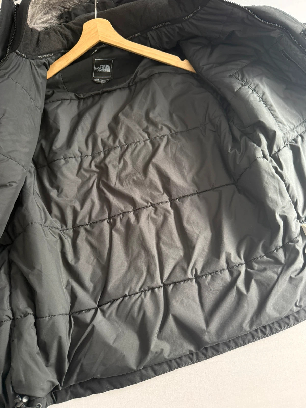 The North Face black parka with detachable faux fur hood and waterproof HyVent technology.