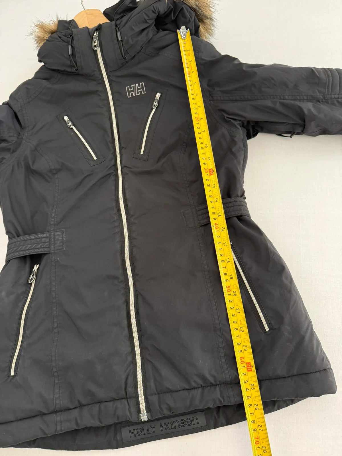 Helly Hansen black ski jacket with detachable faux trim hood and zip pockets.
