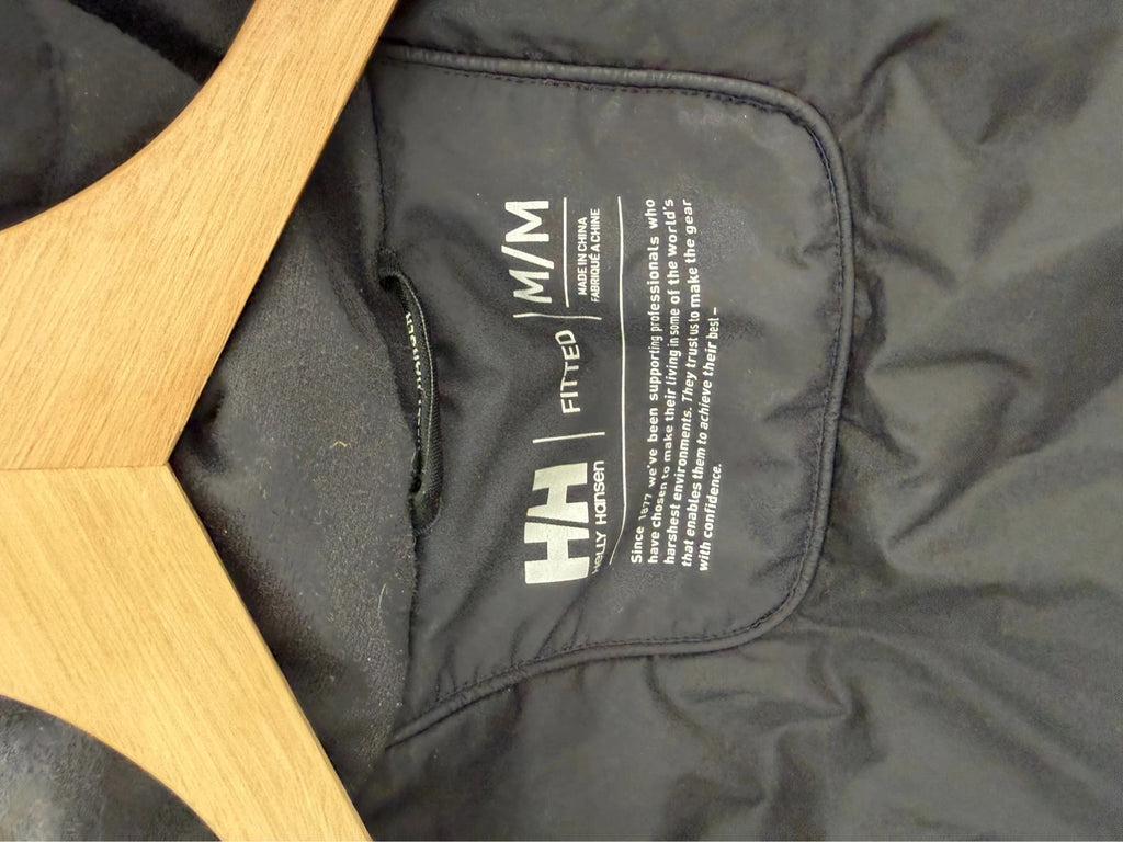 Helly Hansen black ski jacket with detachable faux trim hood and zip pockets.
