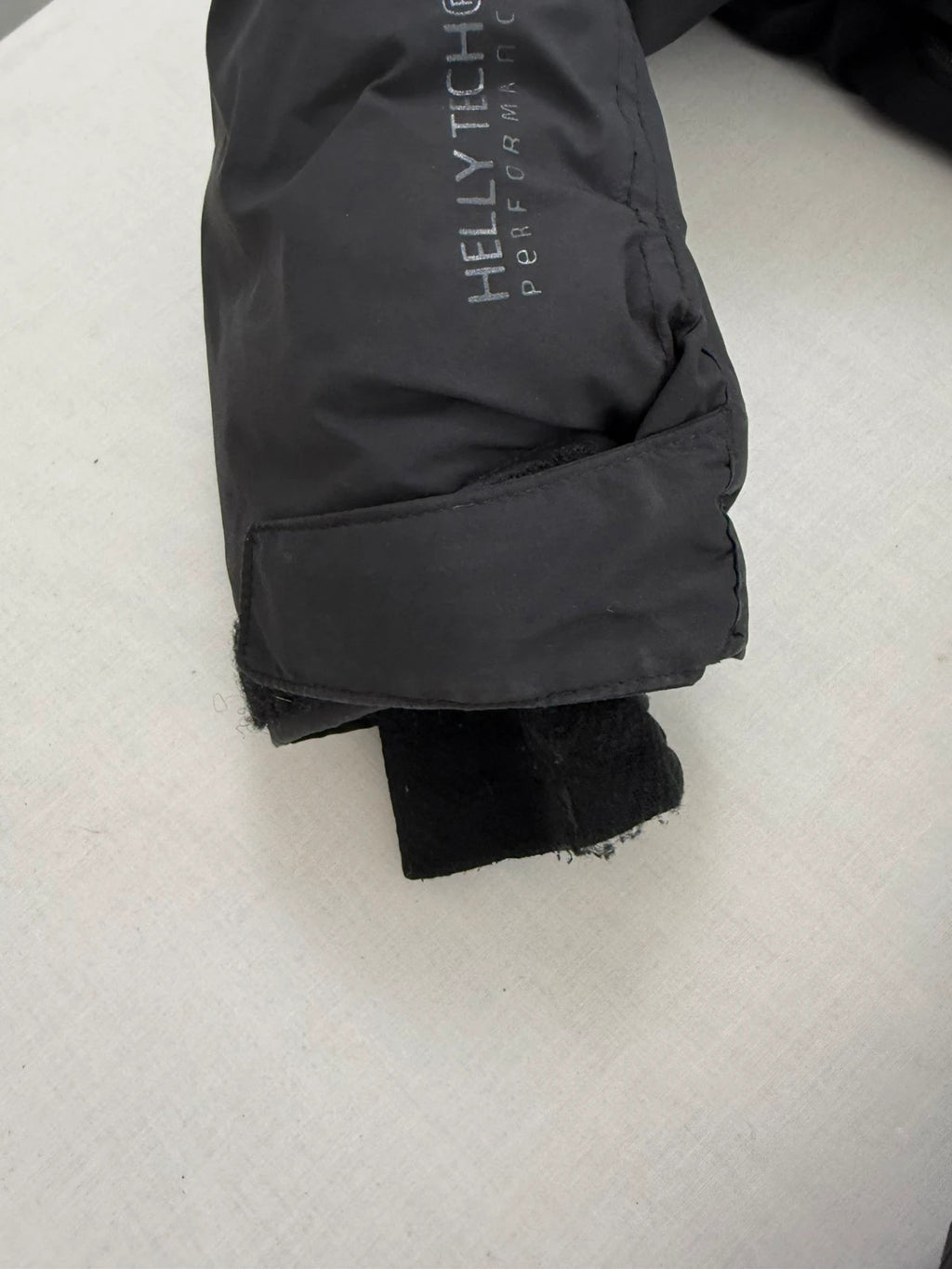 Helly Hansen black ski jacket with detachable faux trim hood and zip pockets.