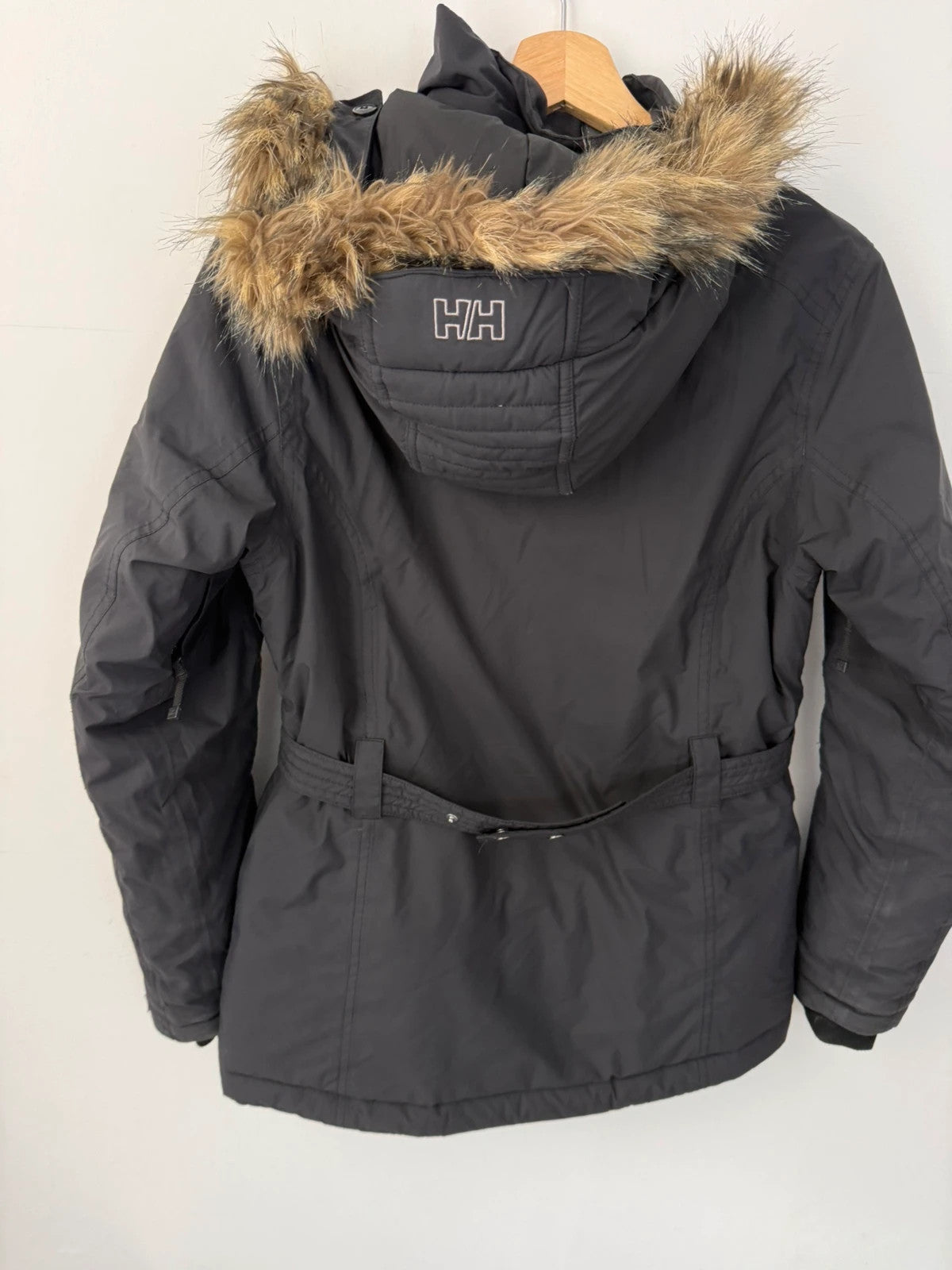 Helly Hansen black ski jacket with detachable faux trim hood and zip pockets.