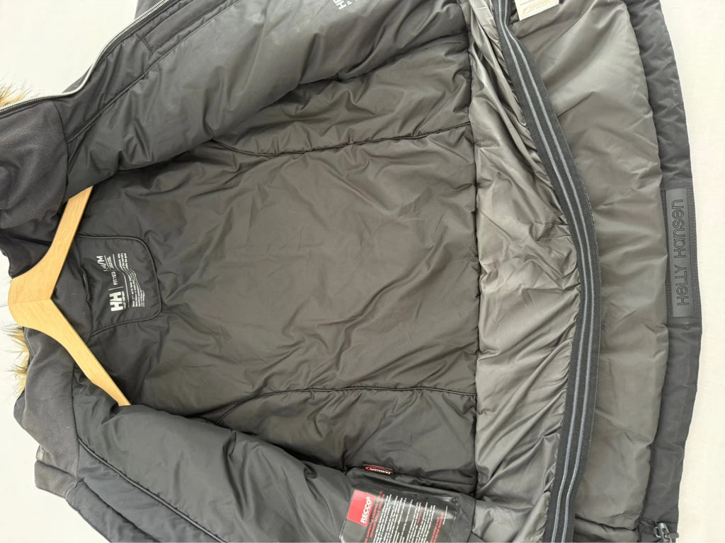 Helly Hansen black ski jacket with detachable faux trim hood and zip pockets.