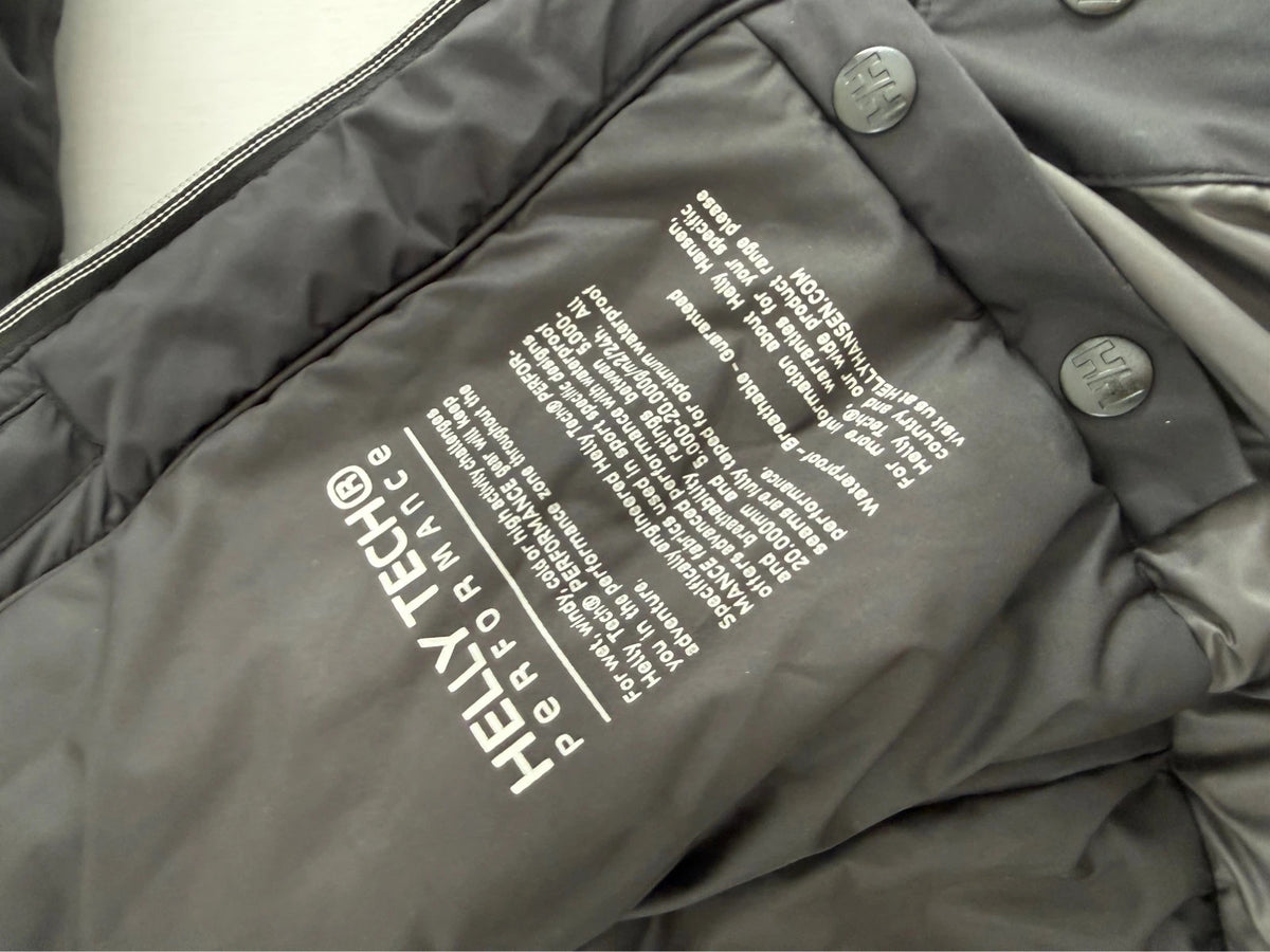 Helly Hansen black ski jacket with detachable faux trim hood and zip pockets.