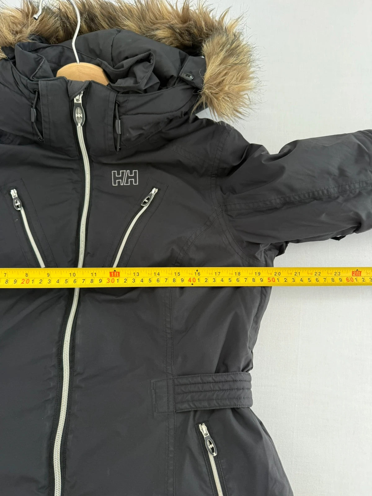 Helly Hansen black ski jacket with detachable faux trim hood and zip pockets.