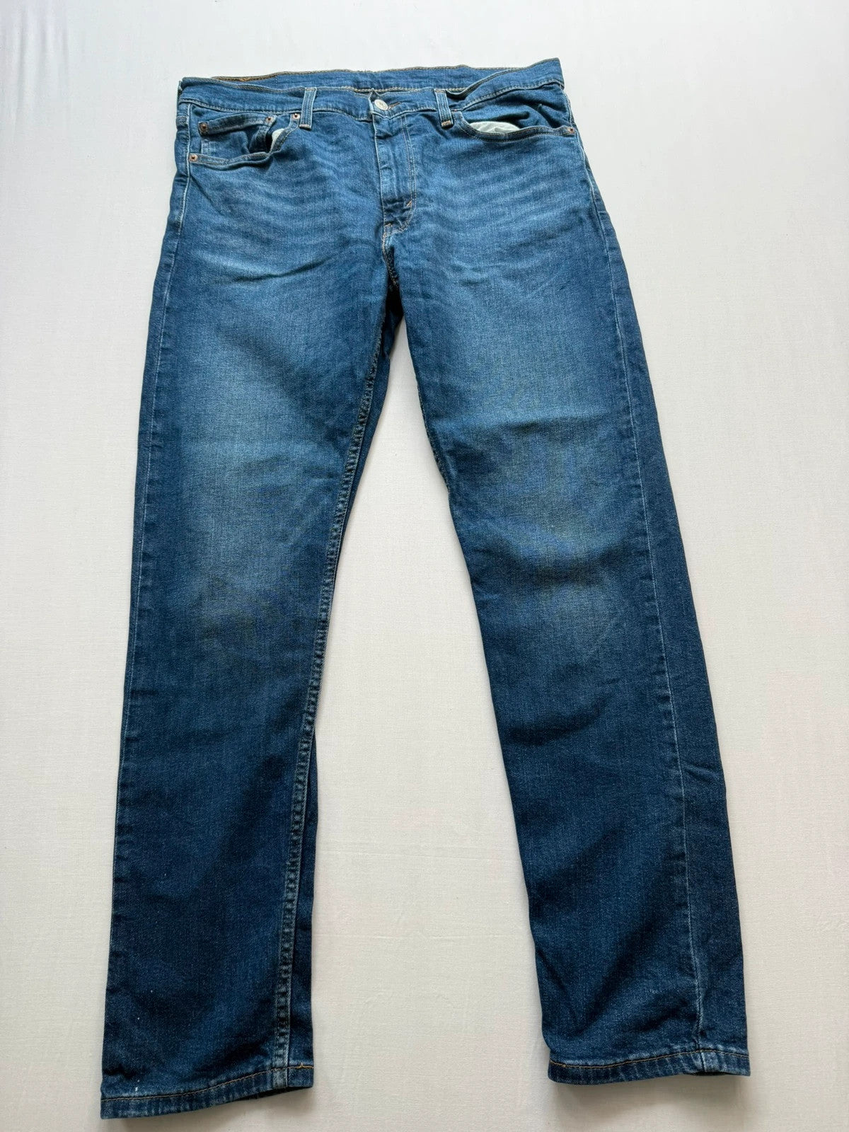 Levi's blue slim tapered jeans with classic five-pocket styling in medium wash.