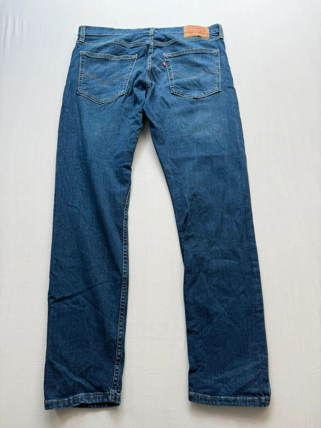 Levi's blue slim tapered jeans with classic five-pocket styling in medium wash.