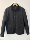 Barbour black quilted jacket with corduroy collar and three front pockets.