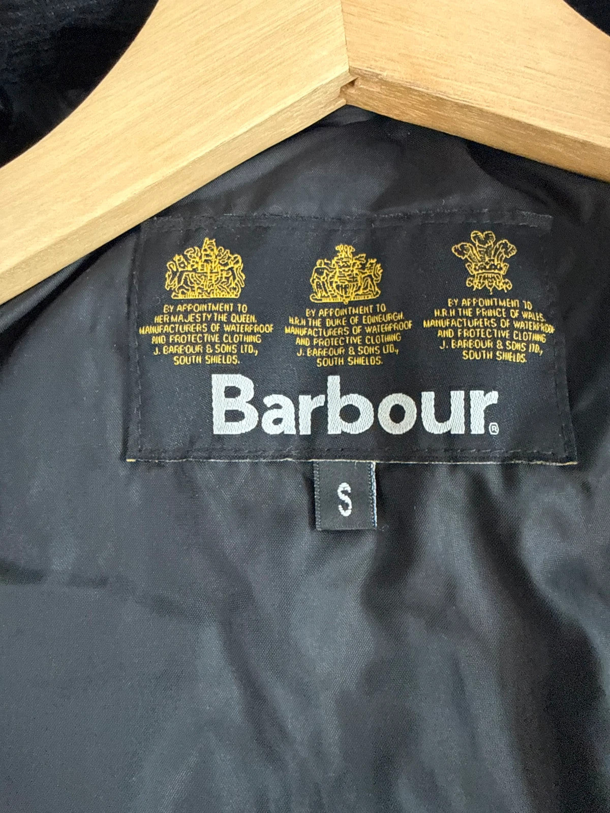 Barbour black quilted jacket with corduroy collar and three front pockets.
