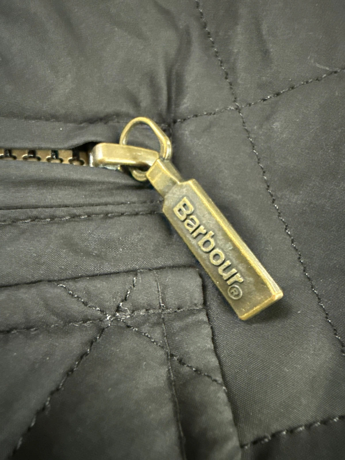 Barbour black quilted jacket with corduroy collar and three front pockets.
