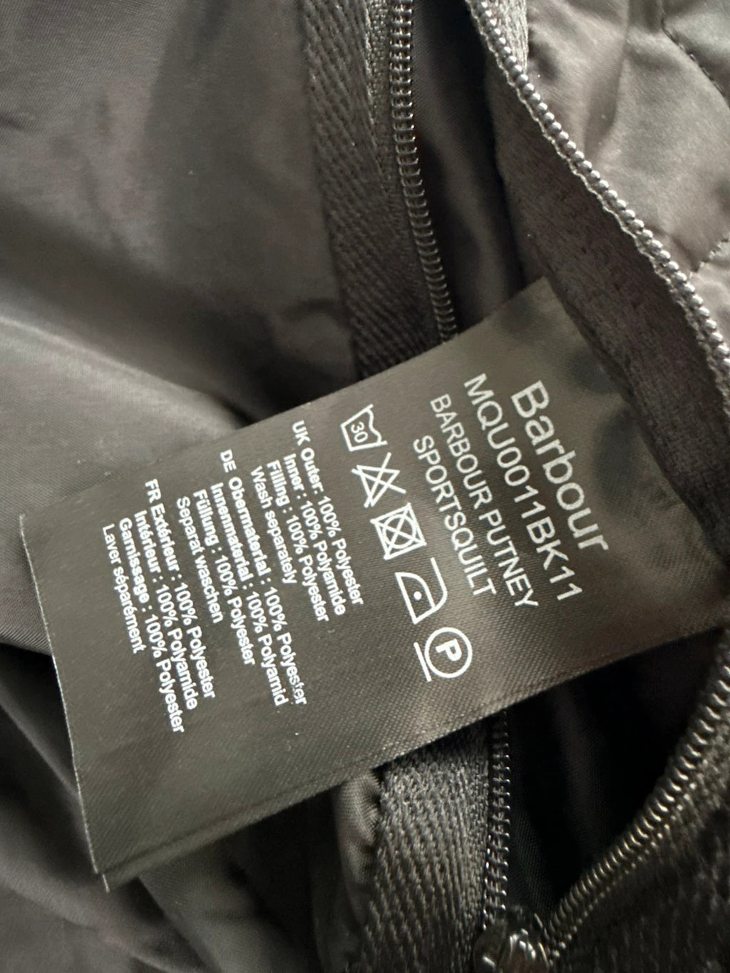 Barbour black quilted jacket with corduroy collar and three front pockets.