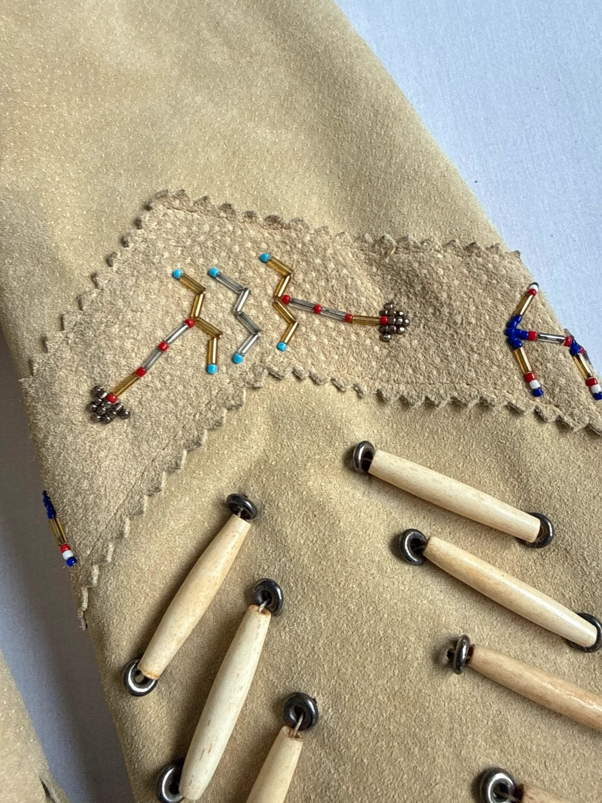 Diamond Leathers tan suede jacket with fringe, beaded arrow detailing, and snap closure.
