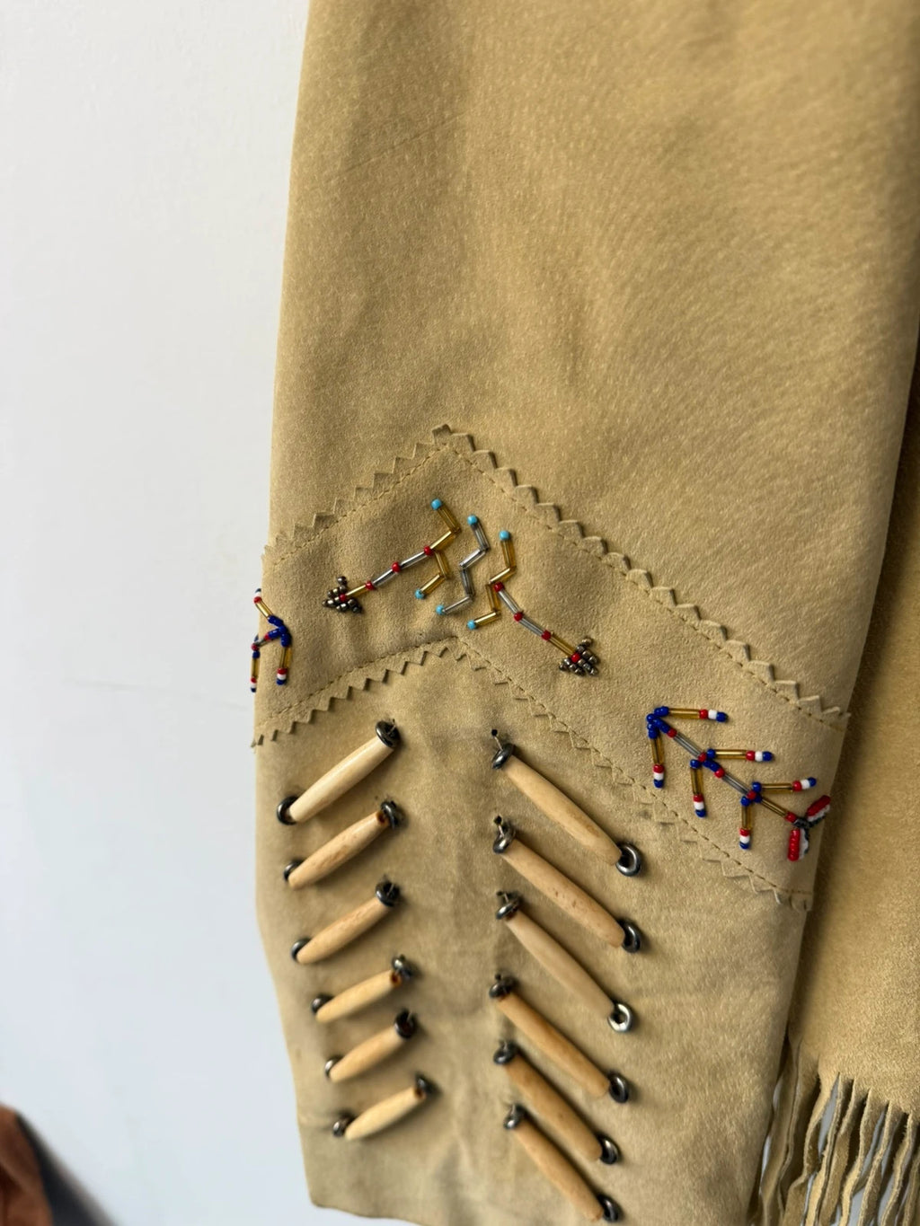 Diamond Leathers tan suede jacket with fringe, beaded arrow detailing, and snap closure.