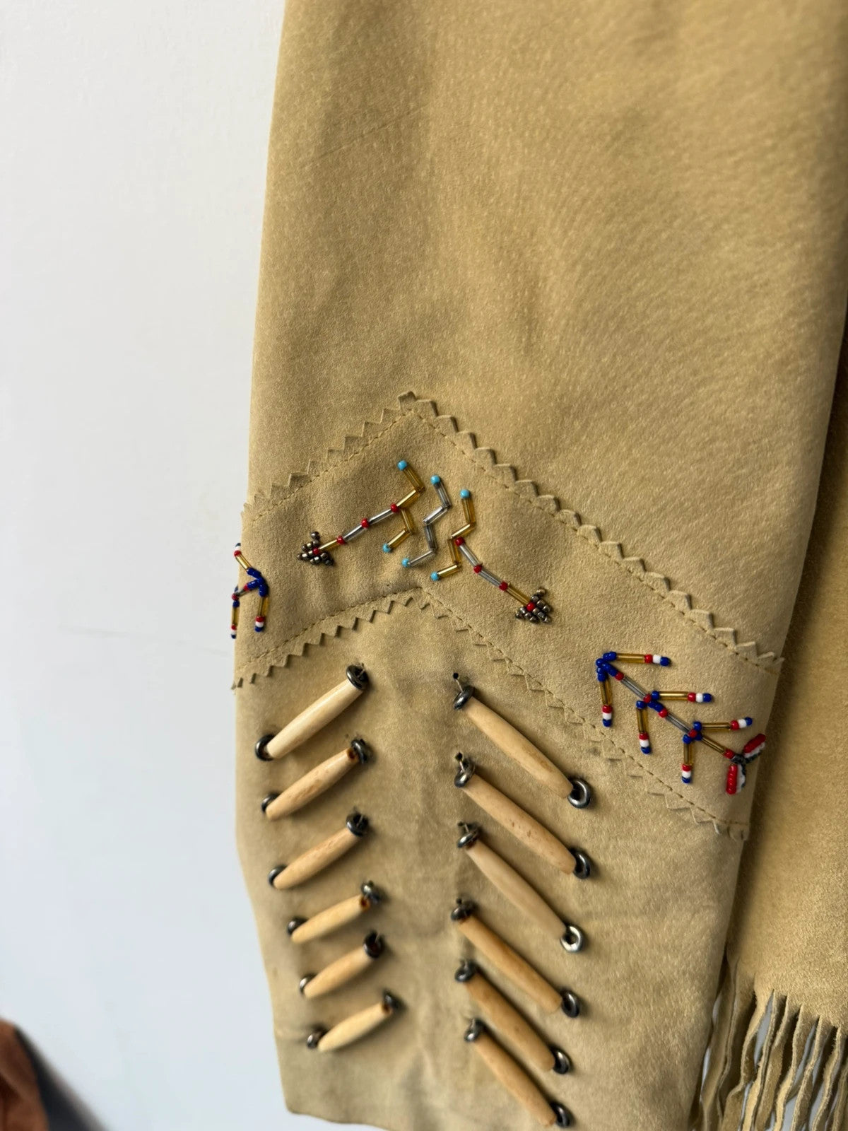 Diamond Leathers tan suede jacket with fringe, beaded arrow detailing, and snap closure.