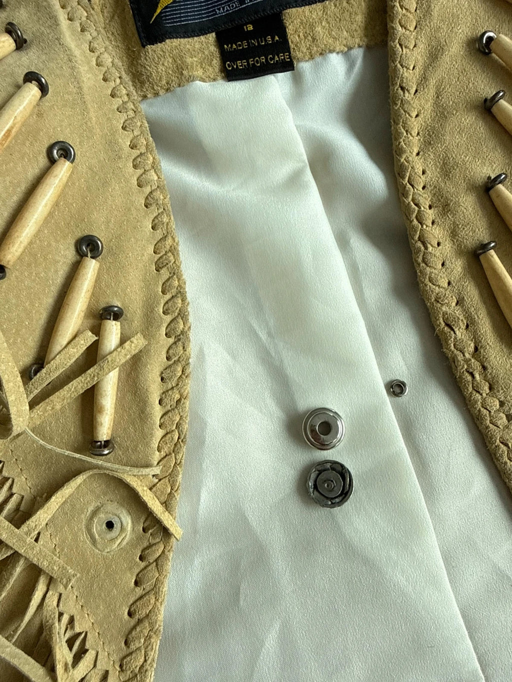 Diamond Leathers tan suede jacket with fringe, beaded arrow detailing, and snap closure.