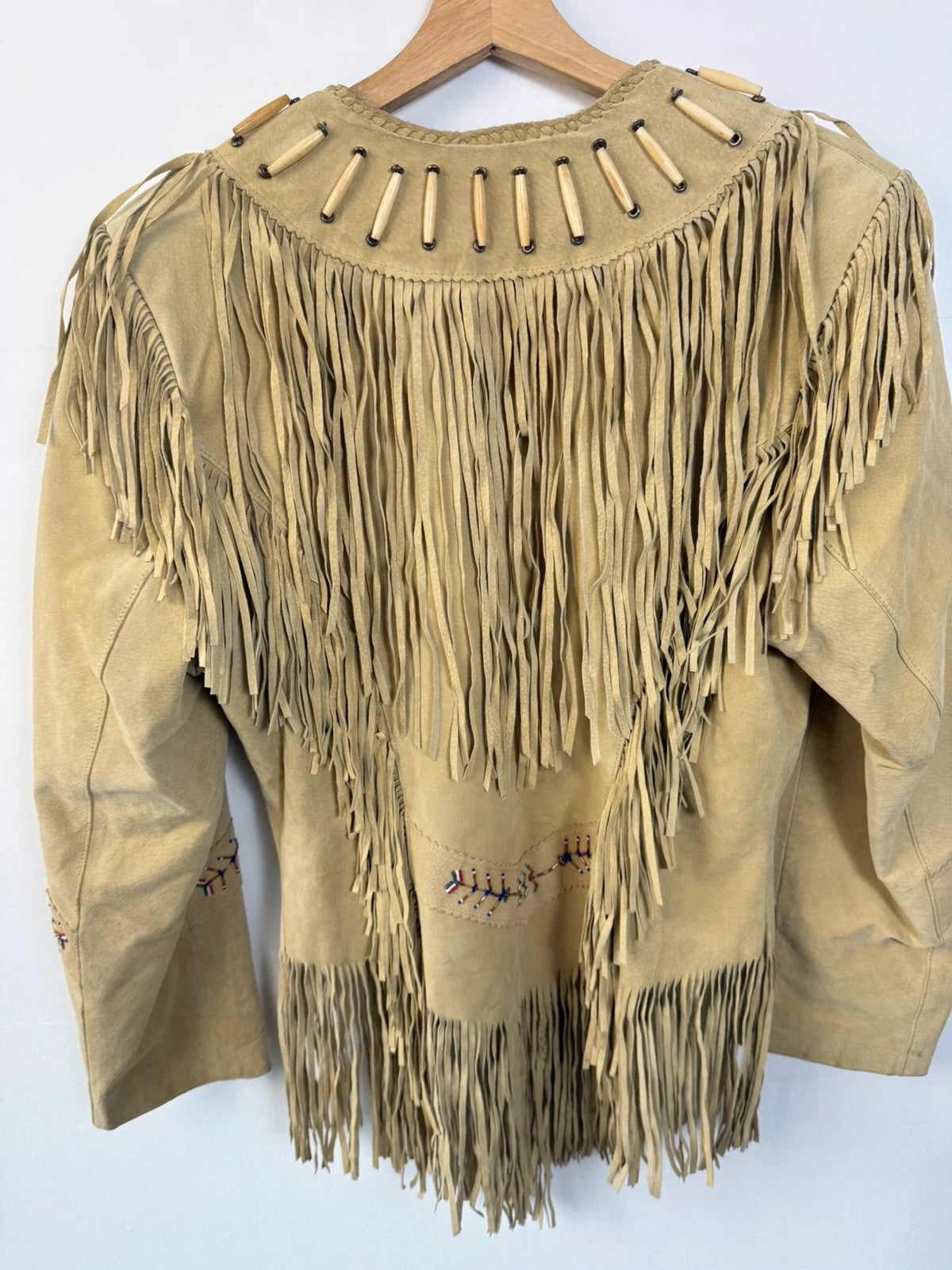 Diamond Leathers tan suede jacket with fringe, beaded arrow detailing, and snap closure.