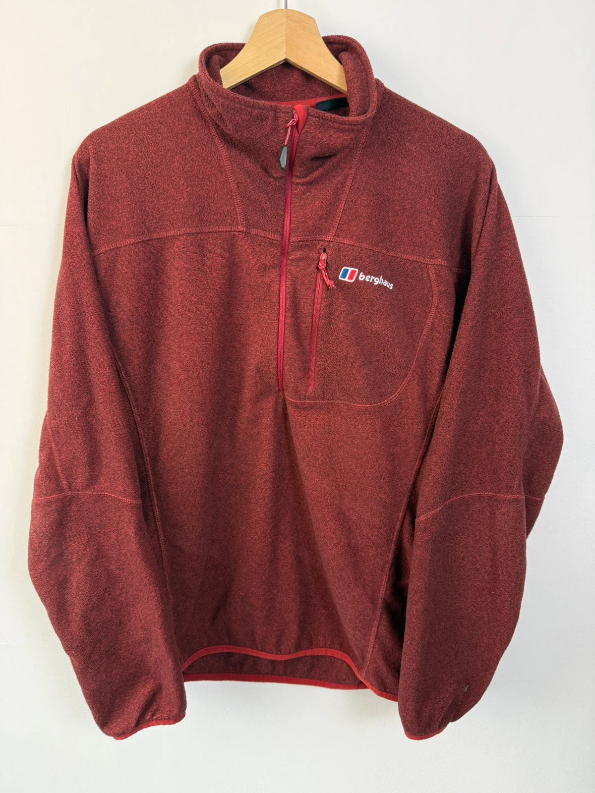 Berghaus burgundy quarter zip fleece with zip chest pocket and adjustable drawcord hem.