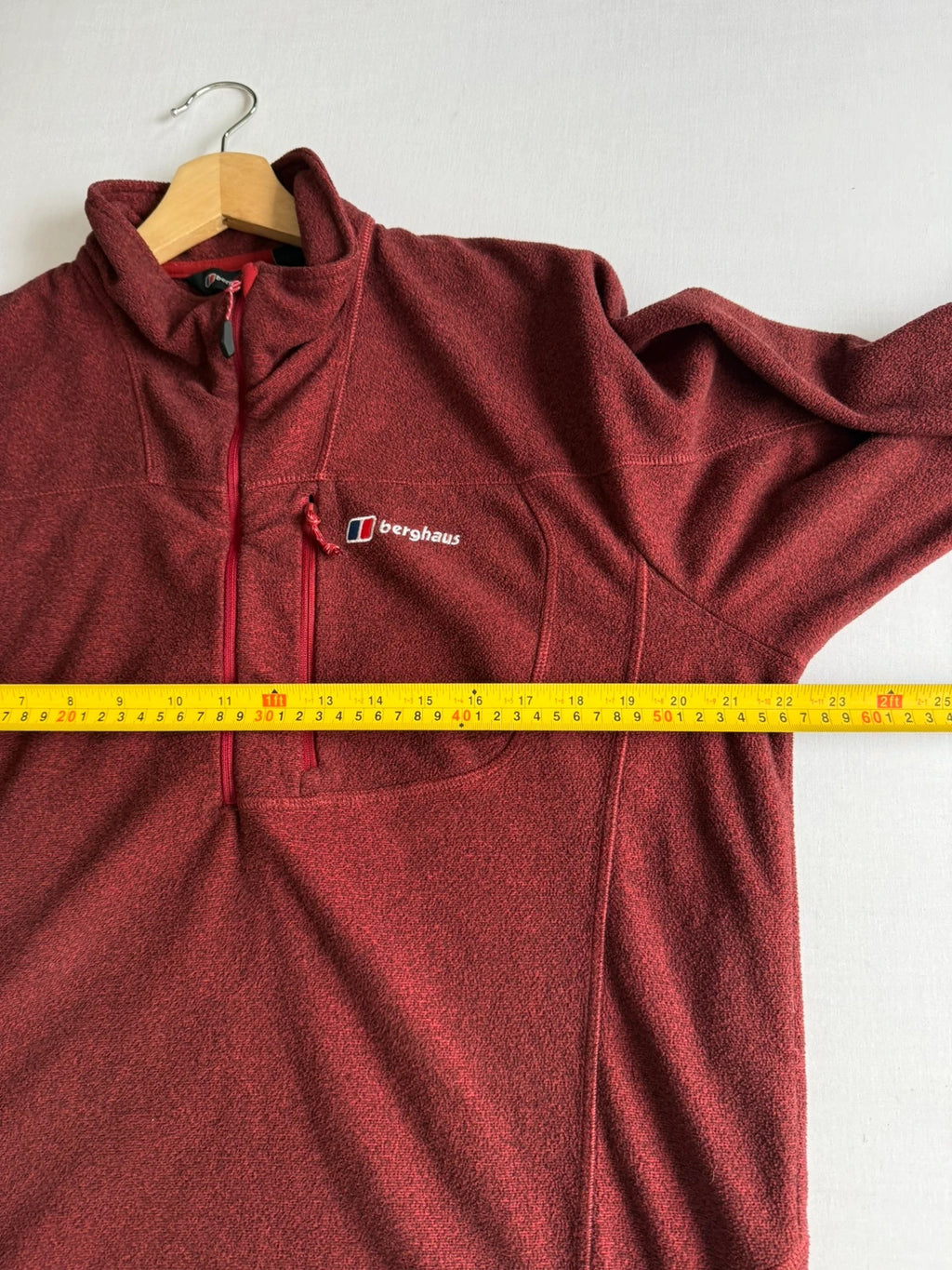 Berghaus burgundy quarter zip fleece with zip chest pocket and adjustable drawcord hem.