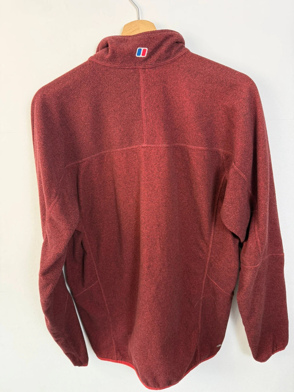 Berghaus burgundy quarter zip fleece with zip chest pocket and adjustable drawcord hem.