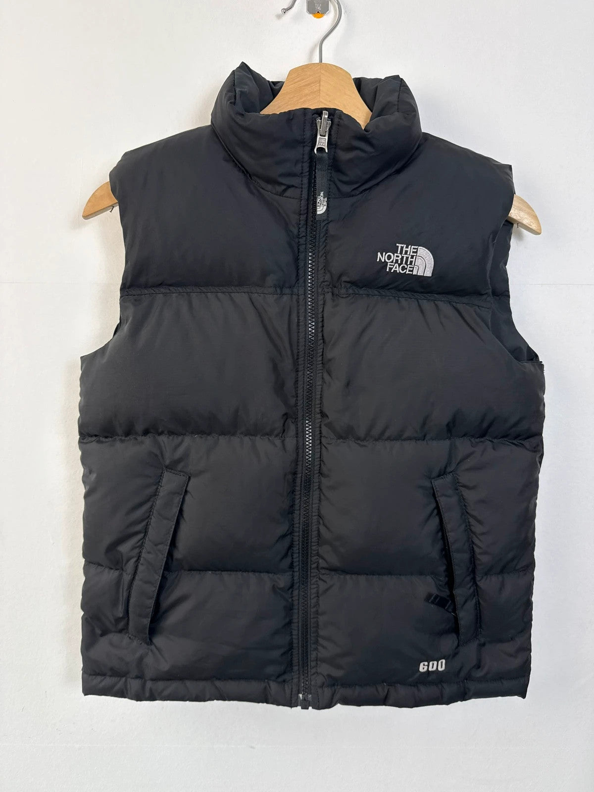 The North Face black puffer gilet with embroidered logo and stand-up collar.