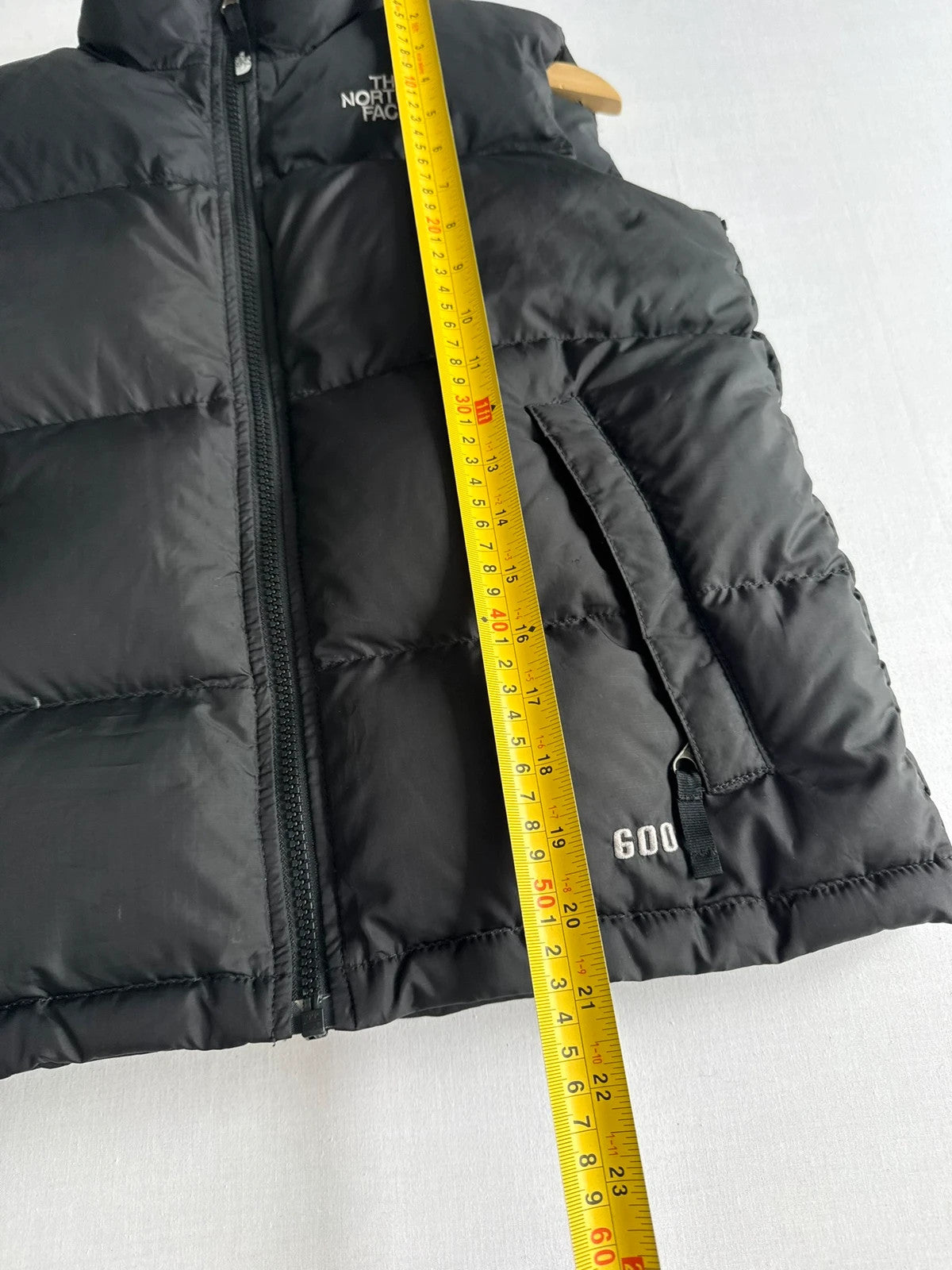 The North Face black puffer gilet with embroidered logo and stand-up collar.