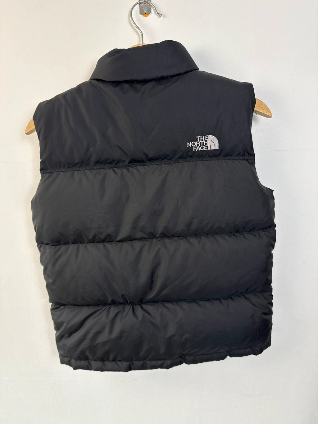 The North Face black puffer gilet with embroidered logo and stand-up collar.