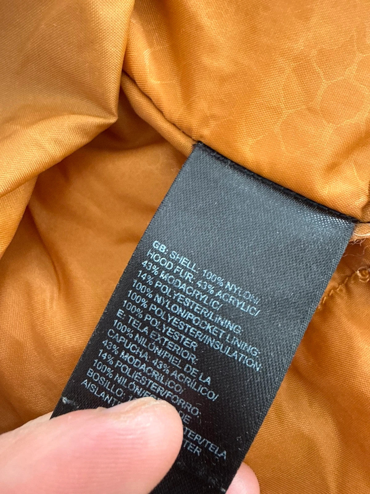 The North Face black ski jacket with tan accents, quilted lining, and multiple pockets.