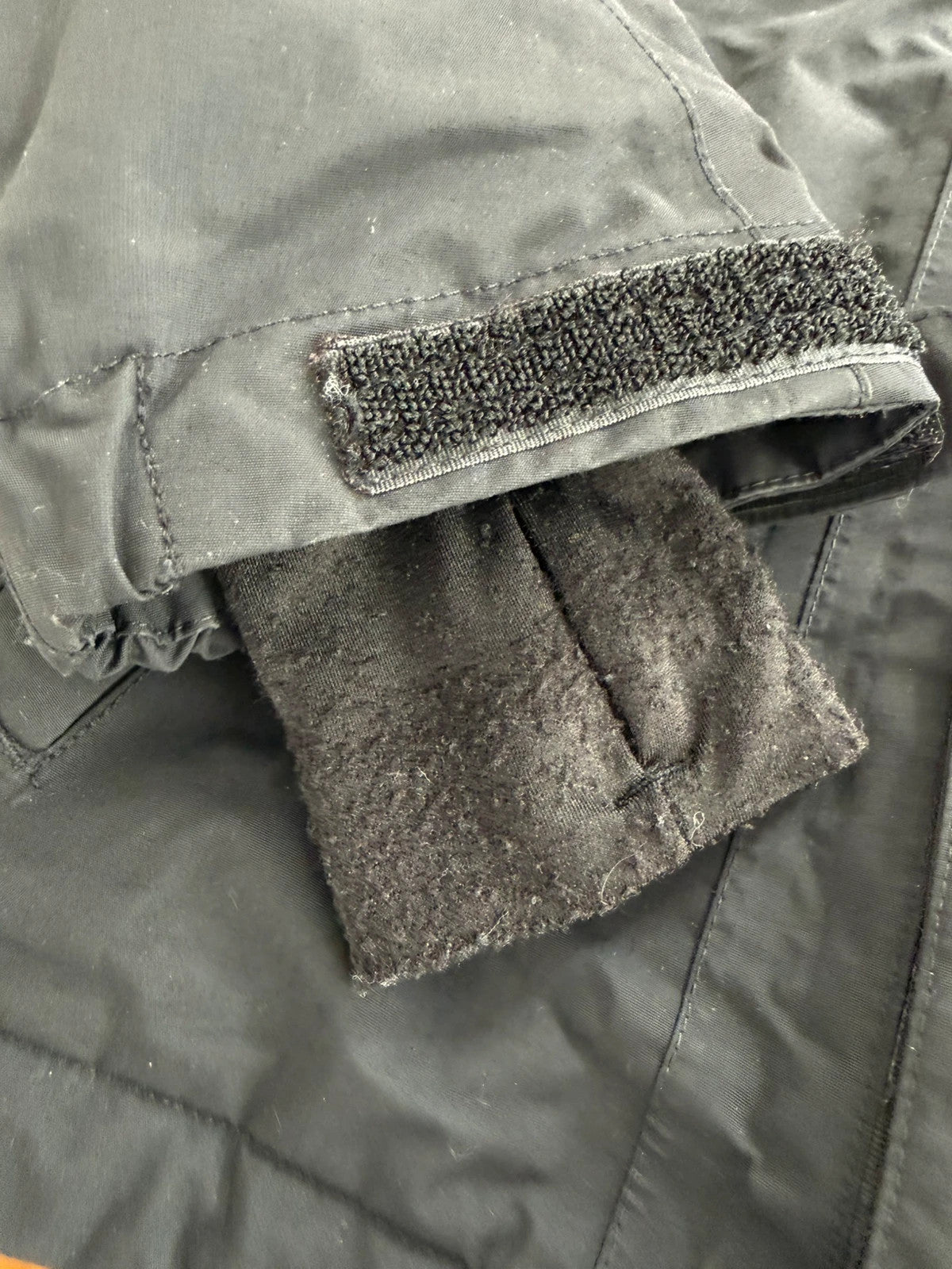 The North Face black ski jacket with tan accents, quilted lining, and multiple pockets.