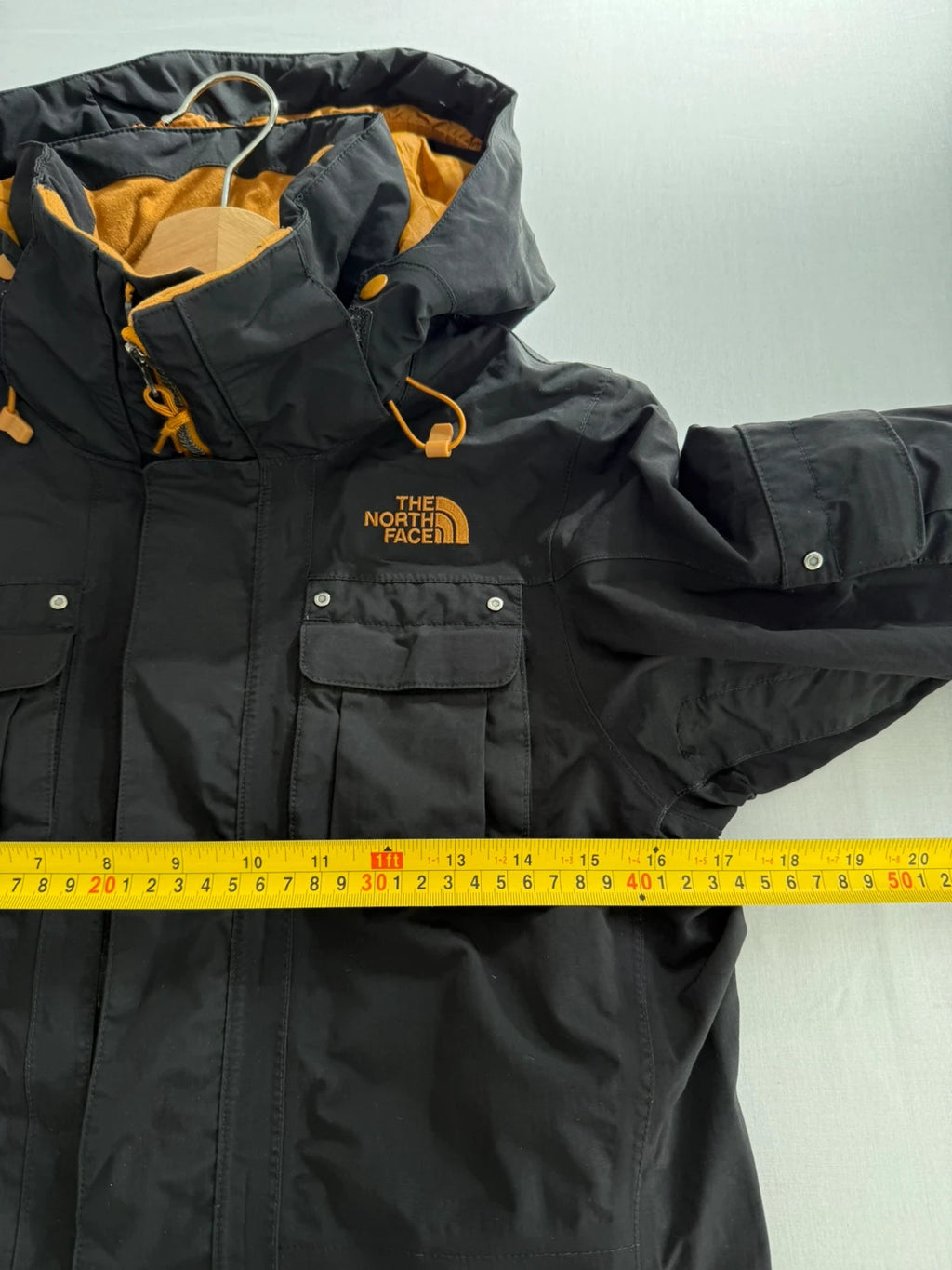 The North Face black ski jacket with tan accents, quilted lining, and multiple pockets.