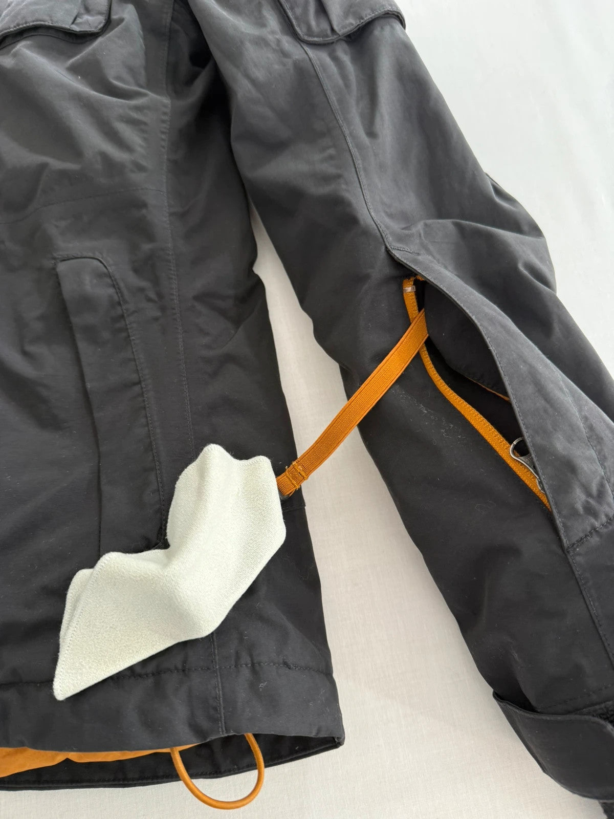 The North Face black ski jacket with tan accents, quilted lining, and multiple pockets.