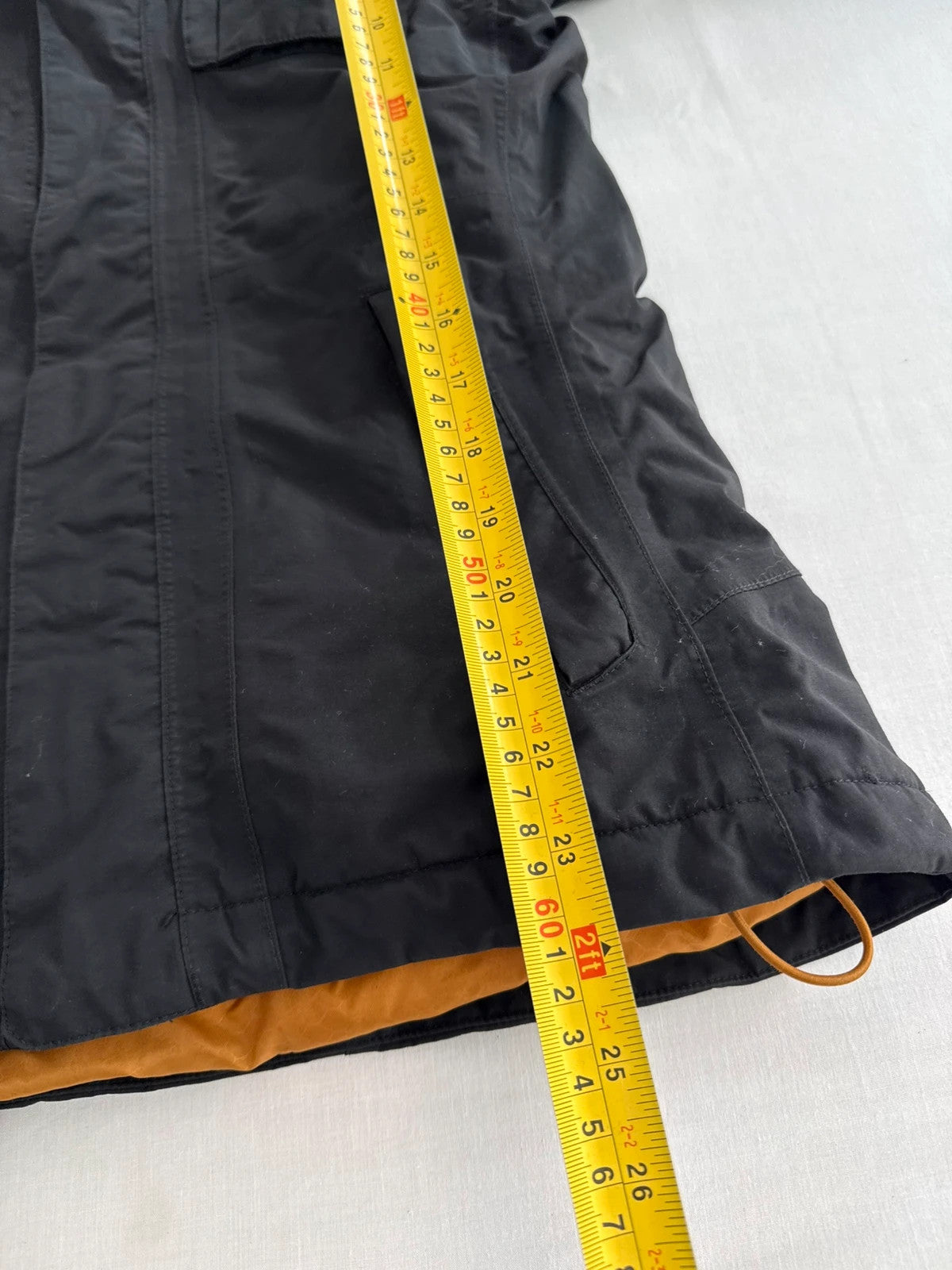 The North Face black ski jacket with tan accents, quilted lining, and multiple pockets.