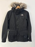 The North Face black ski jacket with faux fleece-lined hood and multiple pockets.