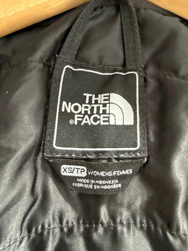 The North Face black ski jacket with faux fleece-lined hood and multiple pockets.
