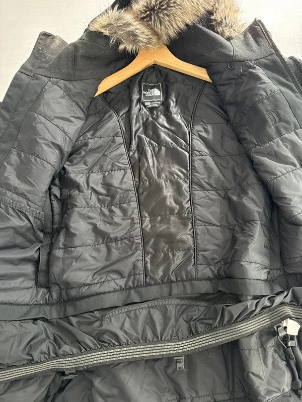 The North Face black ski jacket with faux fleece-lined hood and multiple pockets.