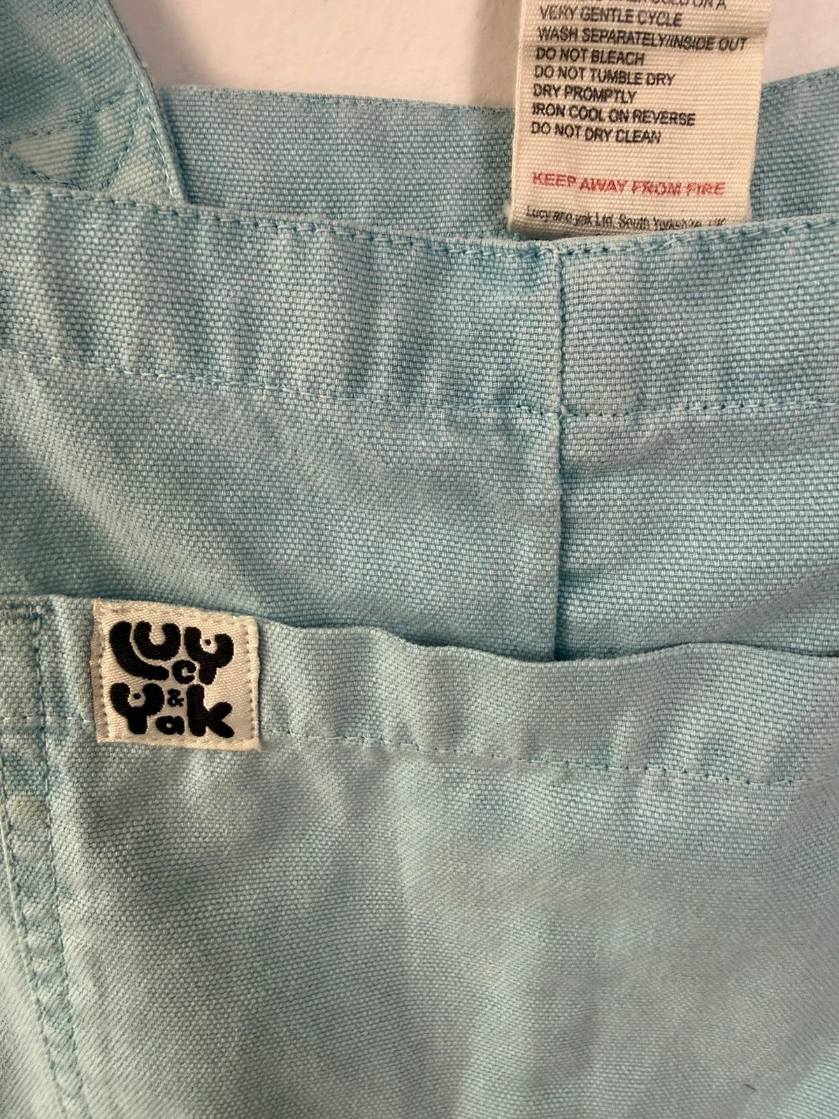 Lucy & Yak light blue dungarees with tie-up straps and large bib pocket, organic cotton.