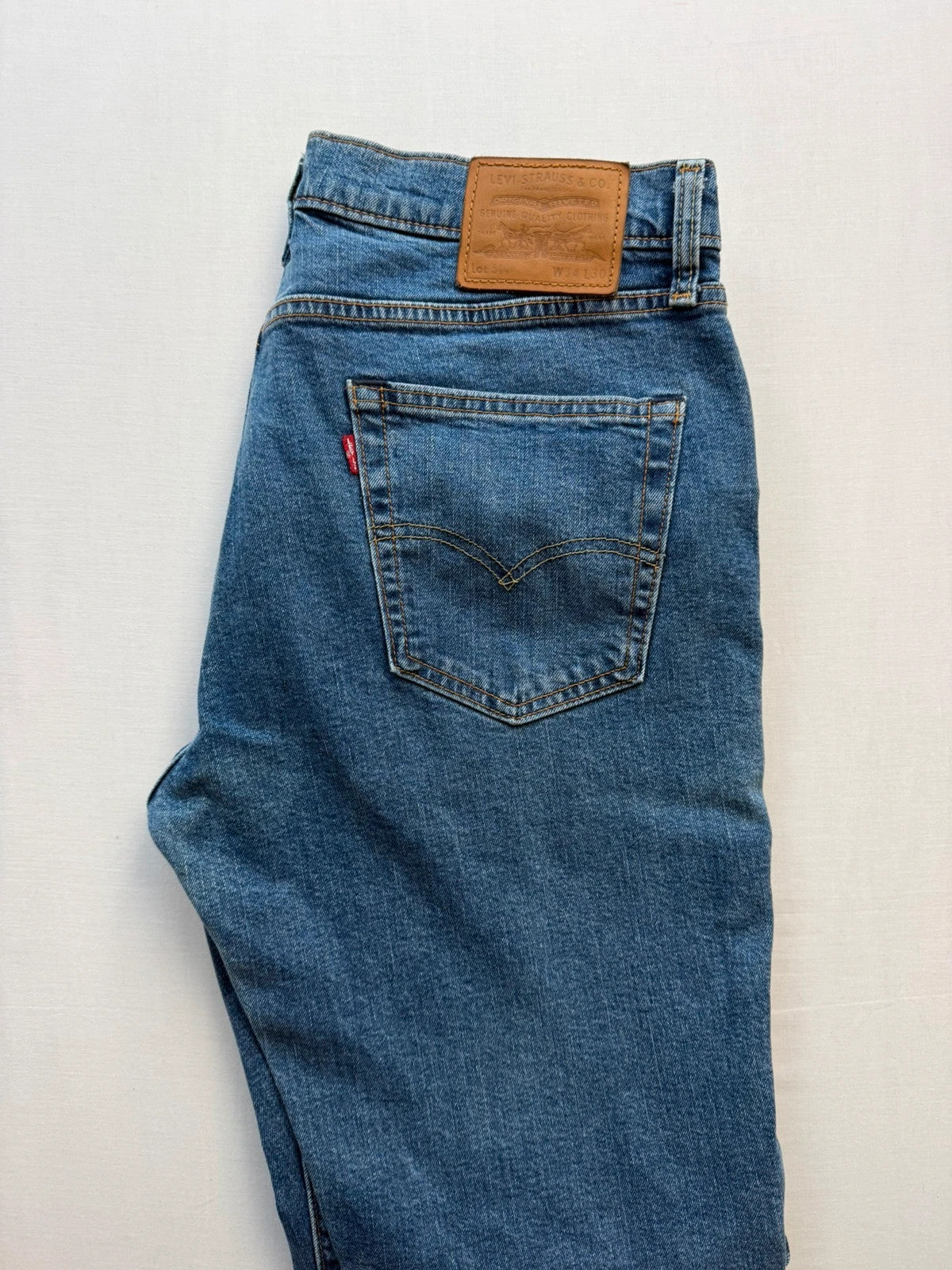 Levi's blue straight jeans with leather back patch and red tab detail.