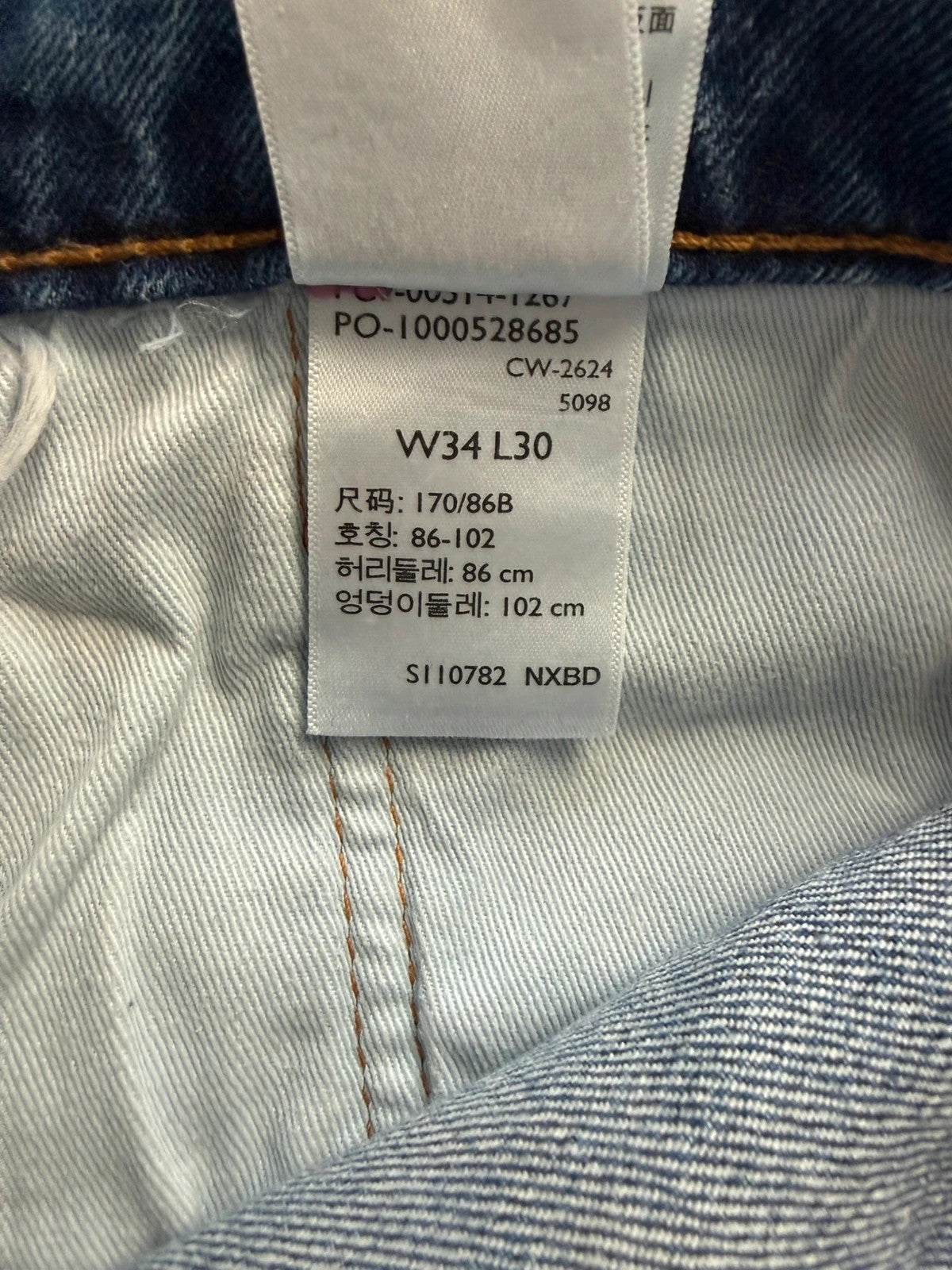 Levi's blue straight jeans with leather back patch and red tab detail.