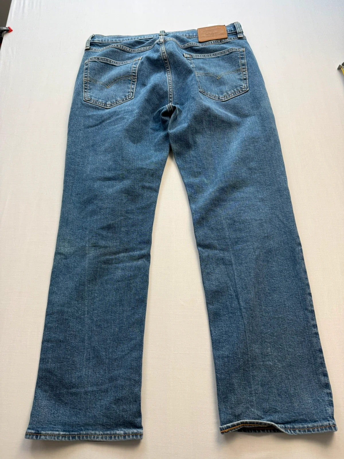 Levi's blue straight jeans with leather back patch and red tab detail.