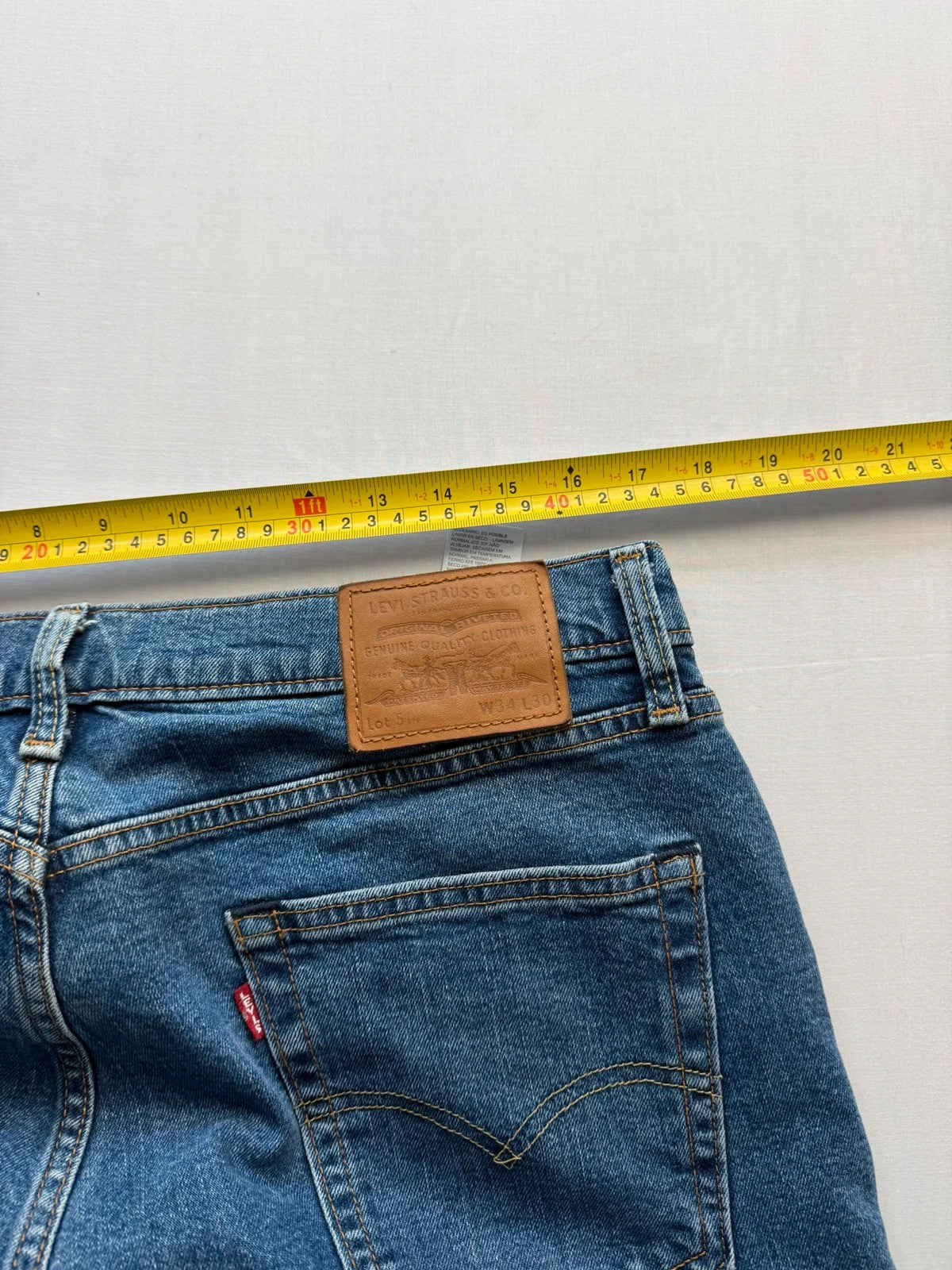 Levi's blue straight jeans with leather back patch and red tab detail.