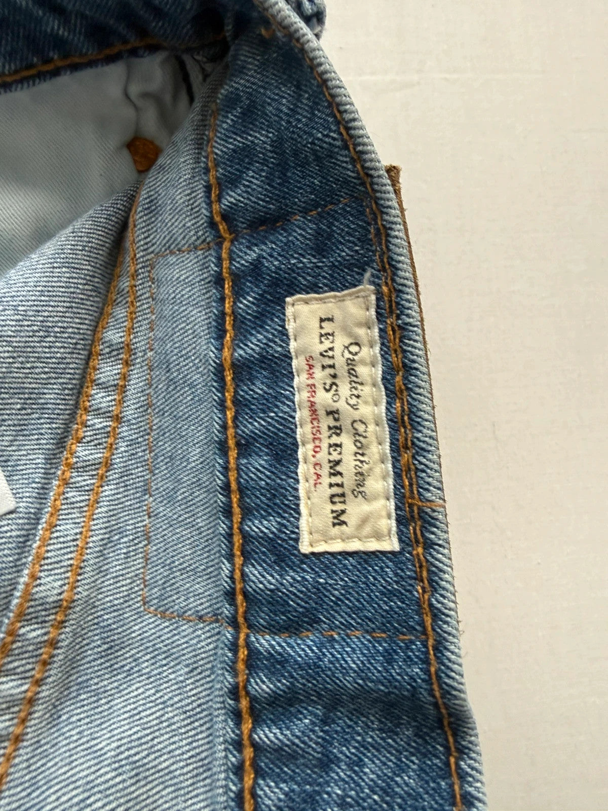 Levi's blue straight jeans with leather back patch and red tab detail.