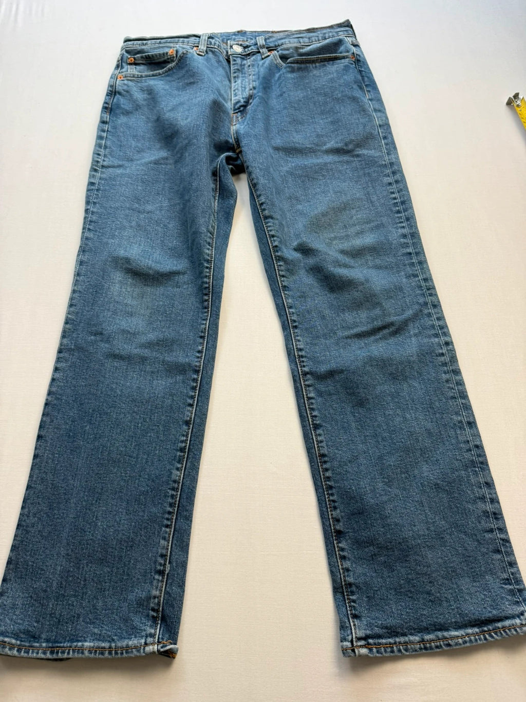 Levi's blue straight jeans with leather back patch and red tab detail.
